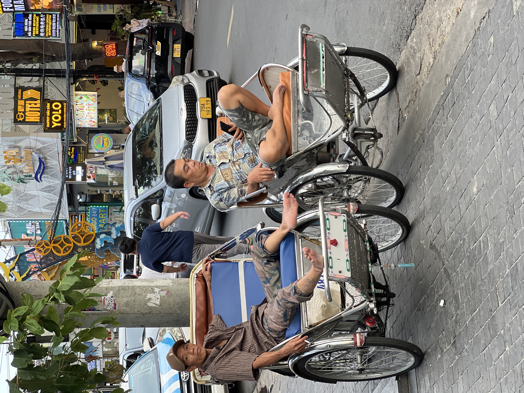 Nha Trang beachfront: vendors, performers, and beach crowds mid-morning