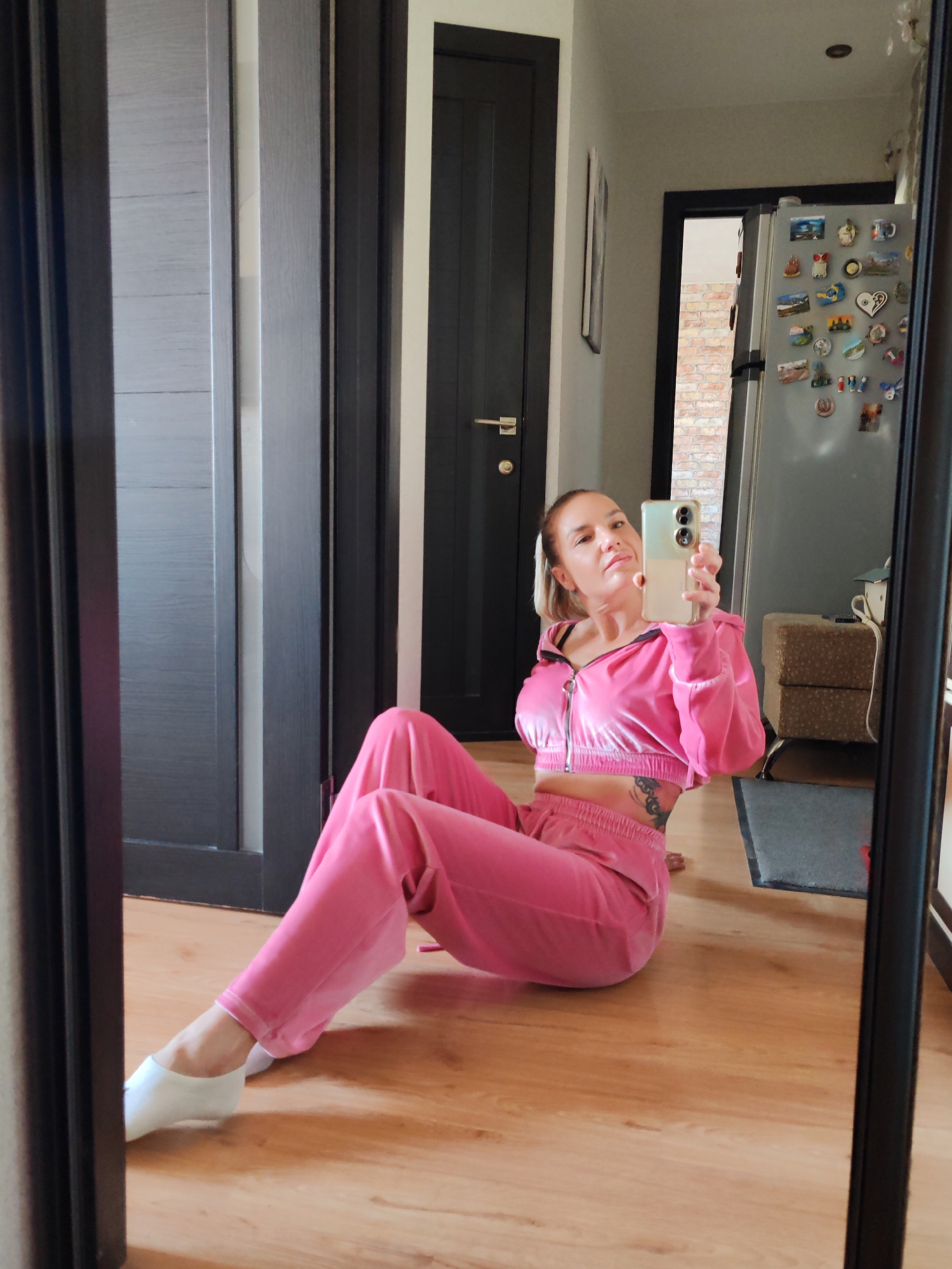 Woman takes mirror selfies in pink tracksuit in Kamchatka
