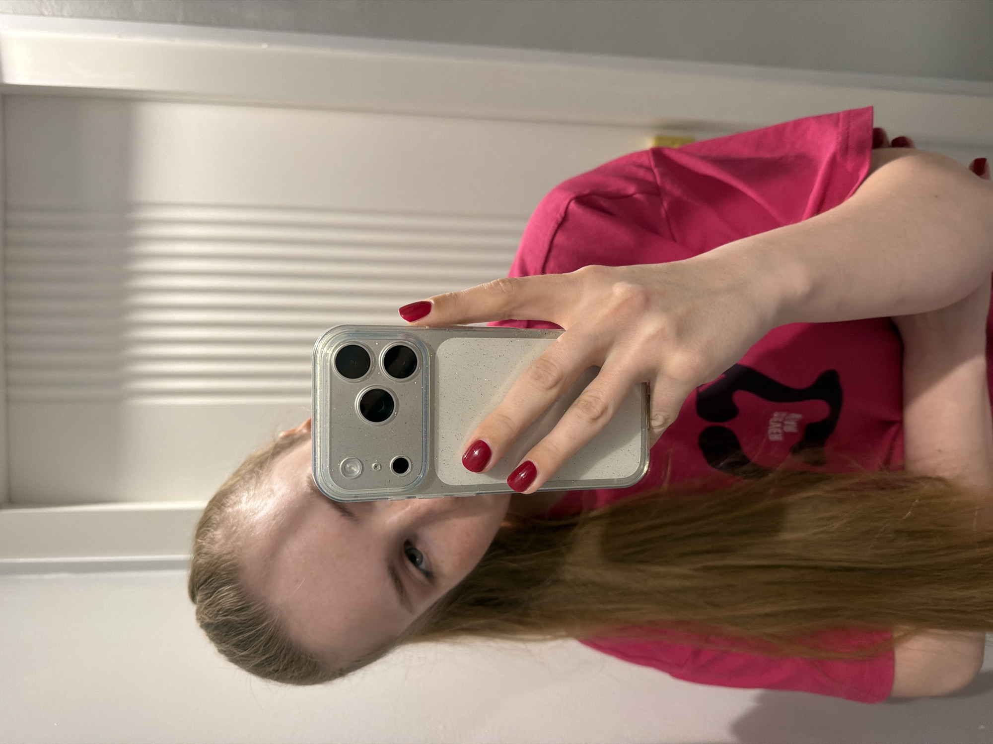 Person takes mirror selfies in pink shirt