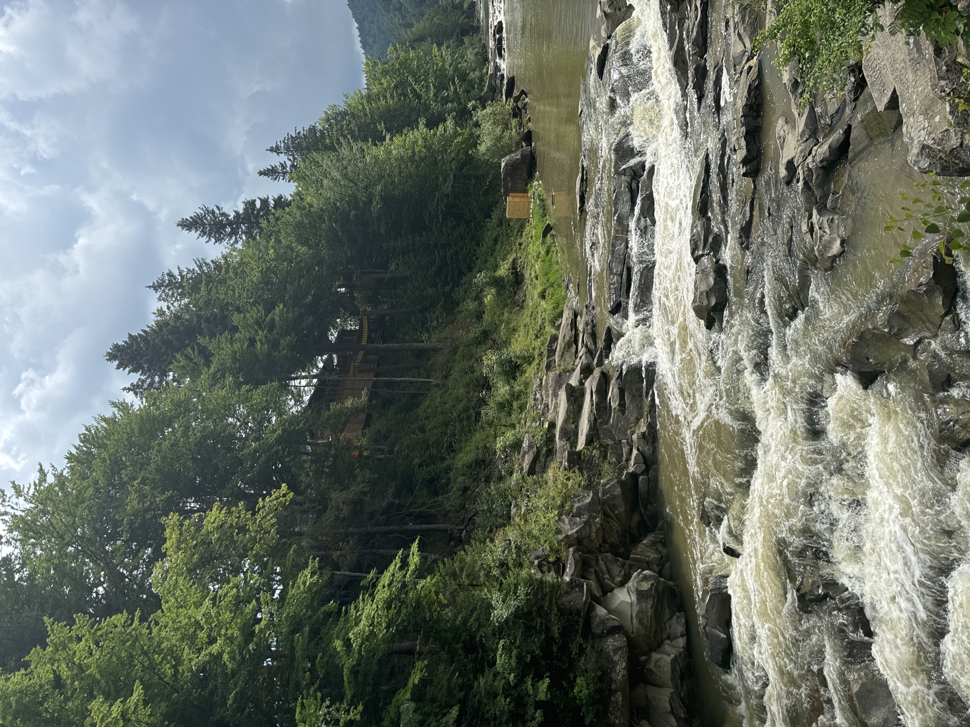 Prut River rapids and flag-lined bridge in Yaremche, Ukraine