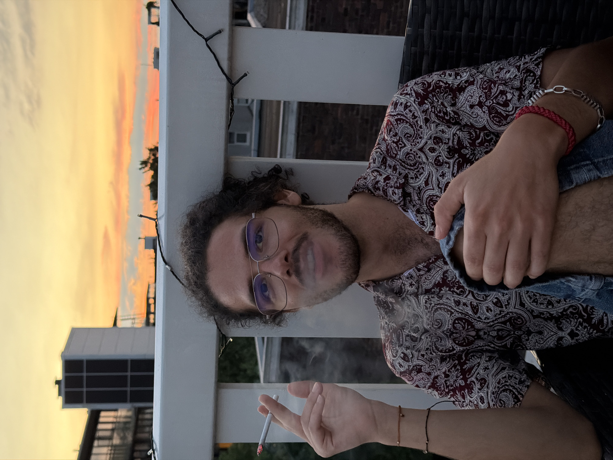 Amsterdam rooftop at golden hour, city skyline at dusk