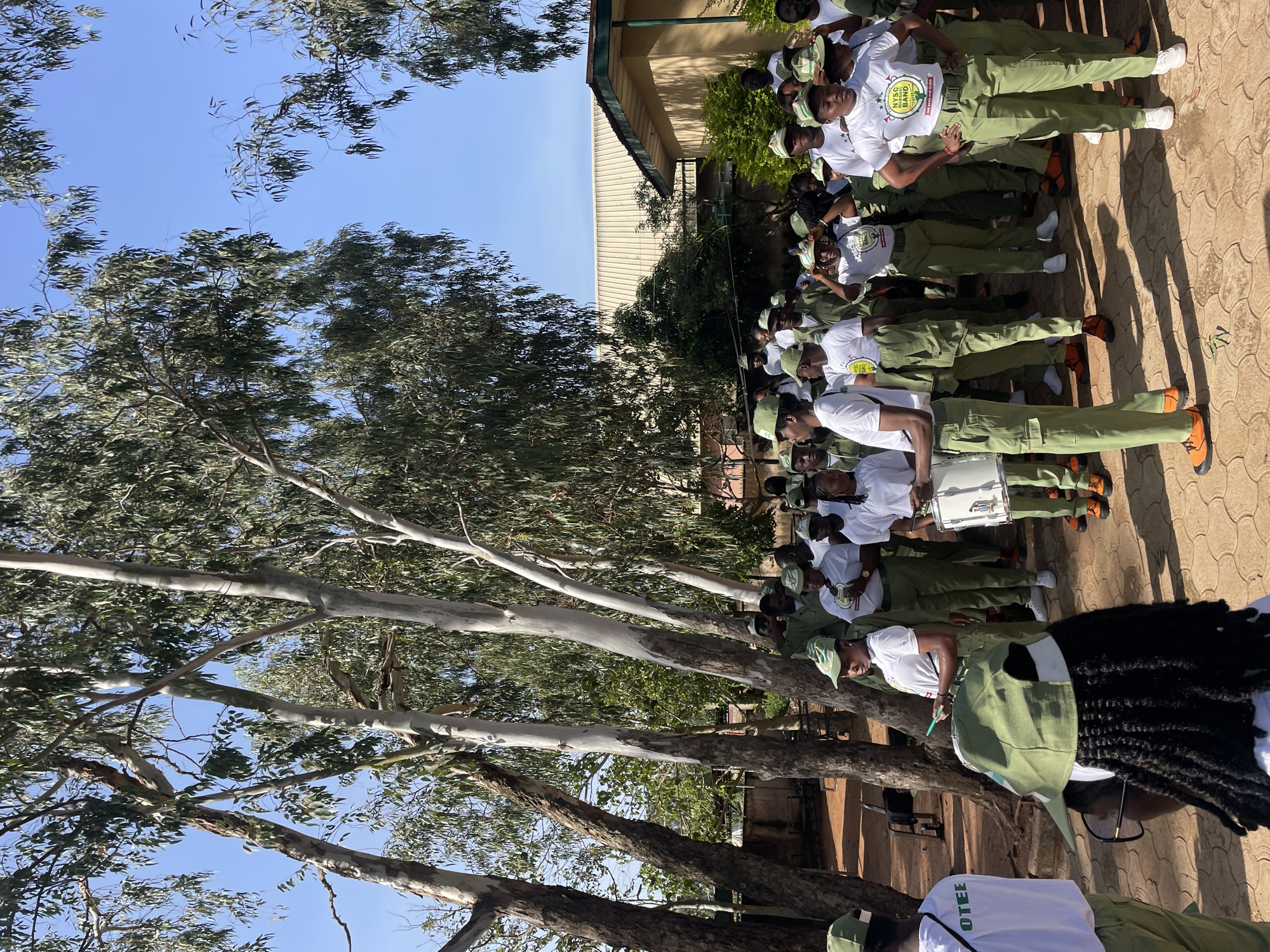 Youth corps members gather with instruments in Jos courtyard