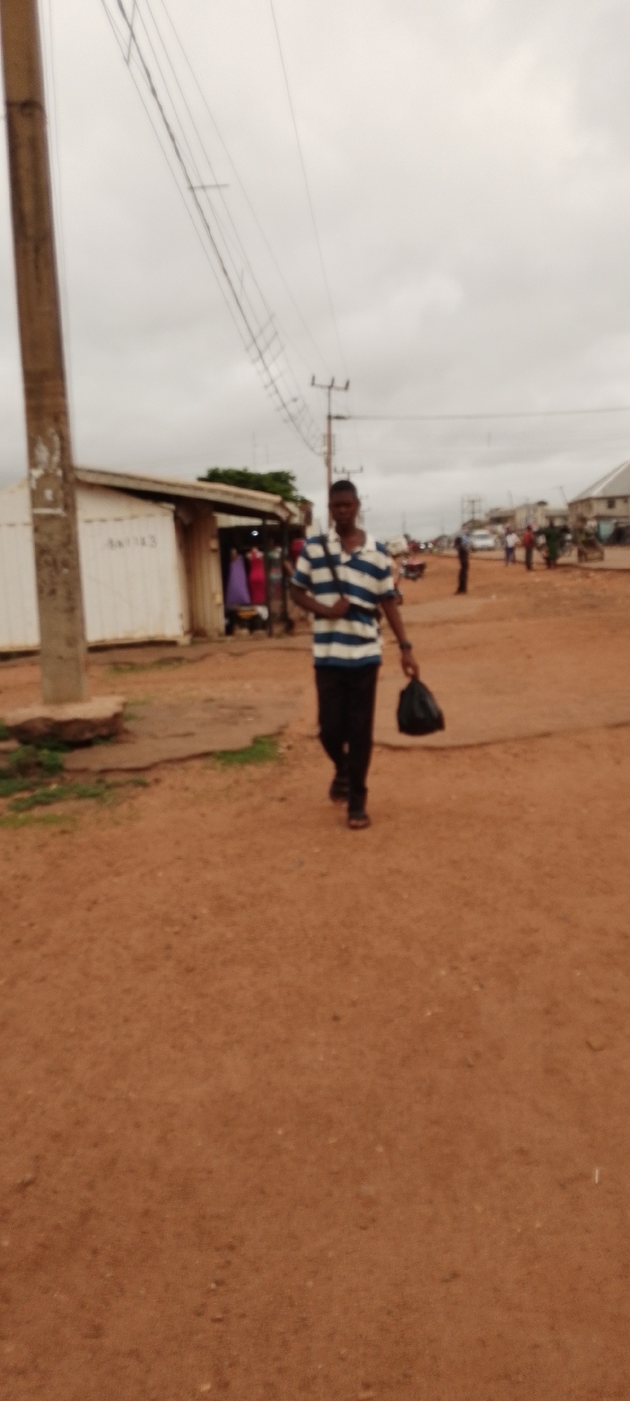Morning street life along a busy dirt road in Gboko, Nigeria