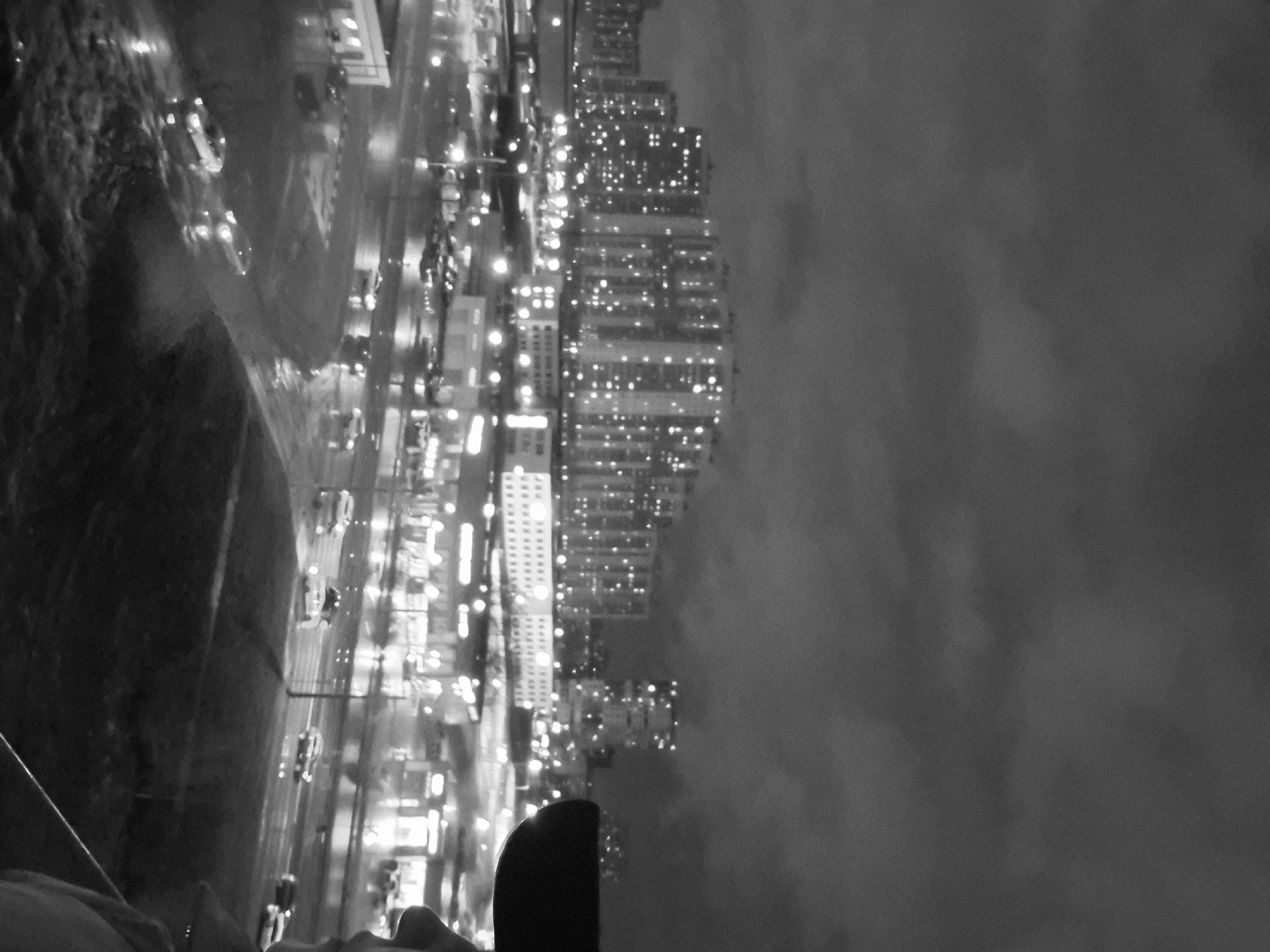 Nighttime cityscape captured showing water reflections, wet conditions