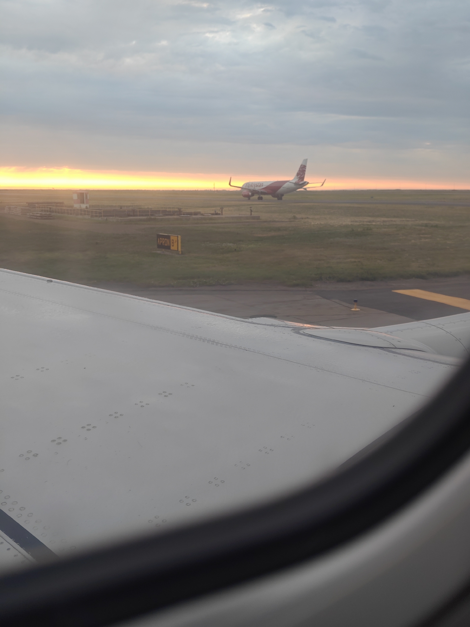 On the ground and airborne at Astana Airport around sunset