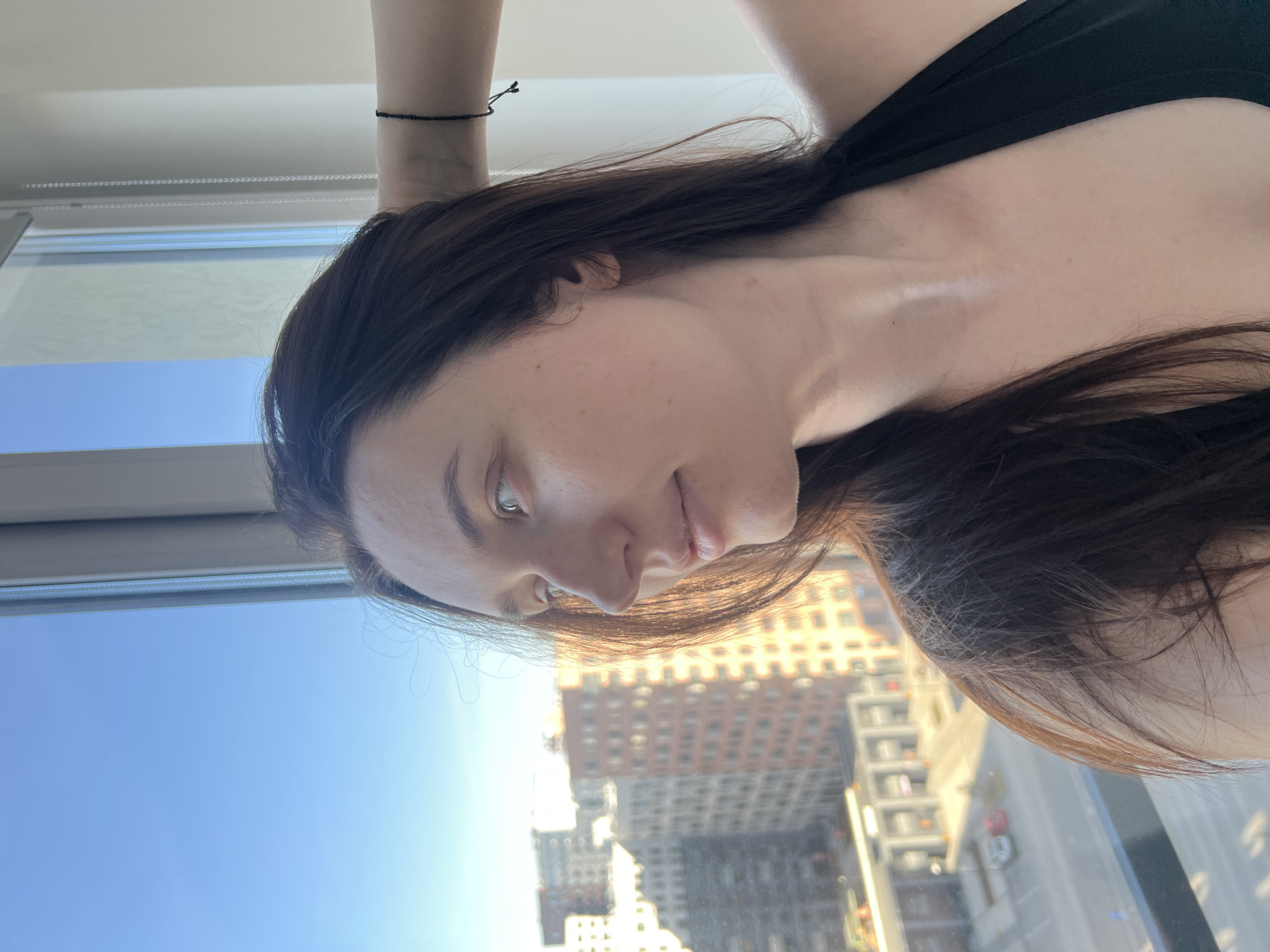 Woman gazes at Tyumen cityscape through window