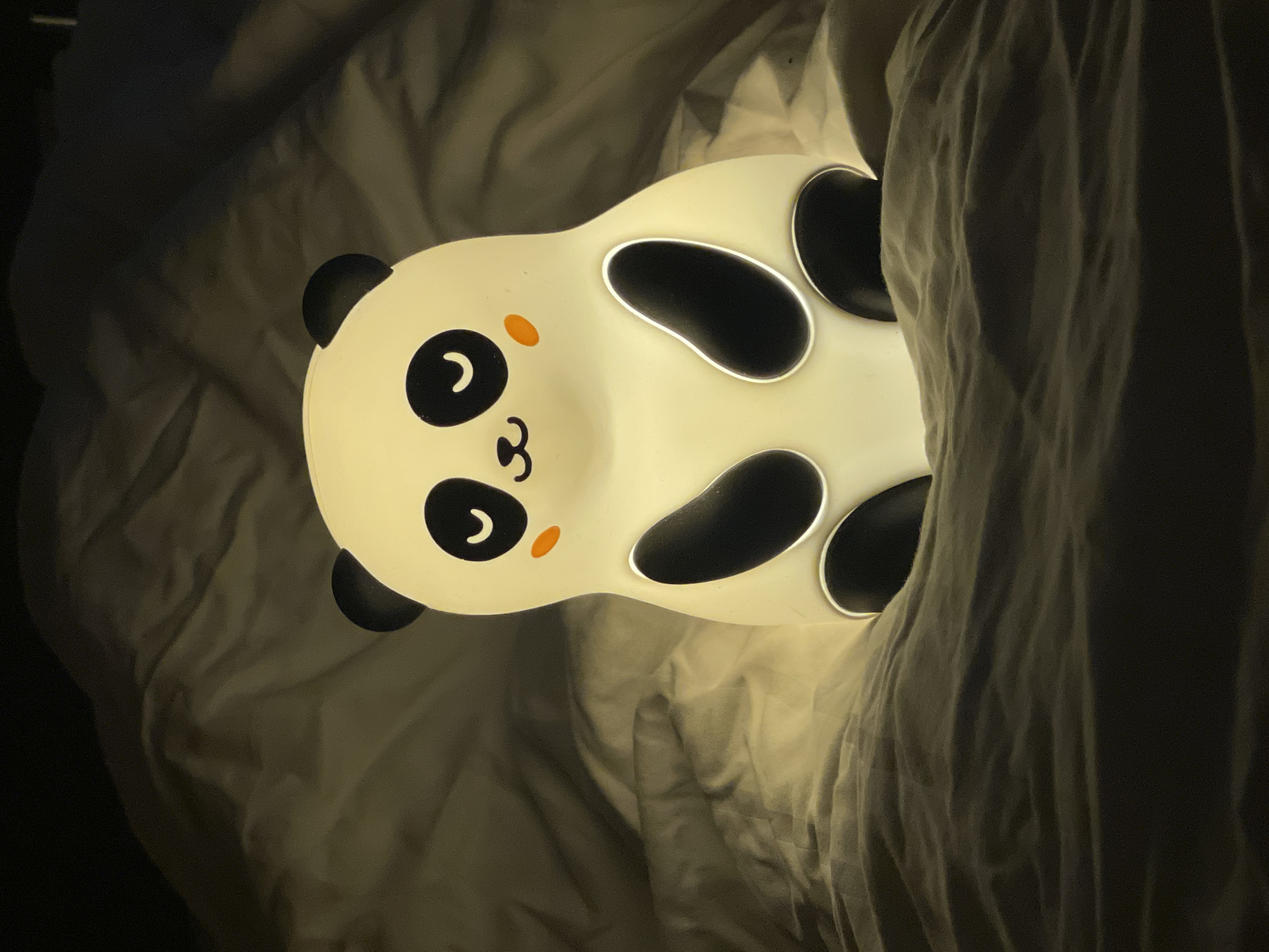 Panda nightlight photographed repeatedly on bed in German bedroom