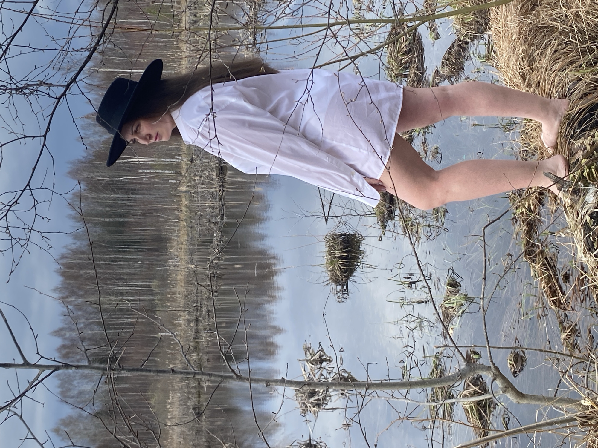 Woman stands barefoot in shallow water near Markovo, Russia