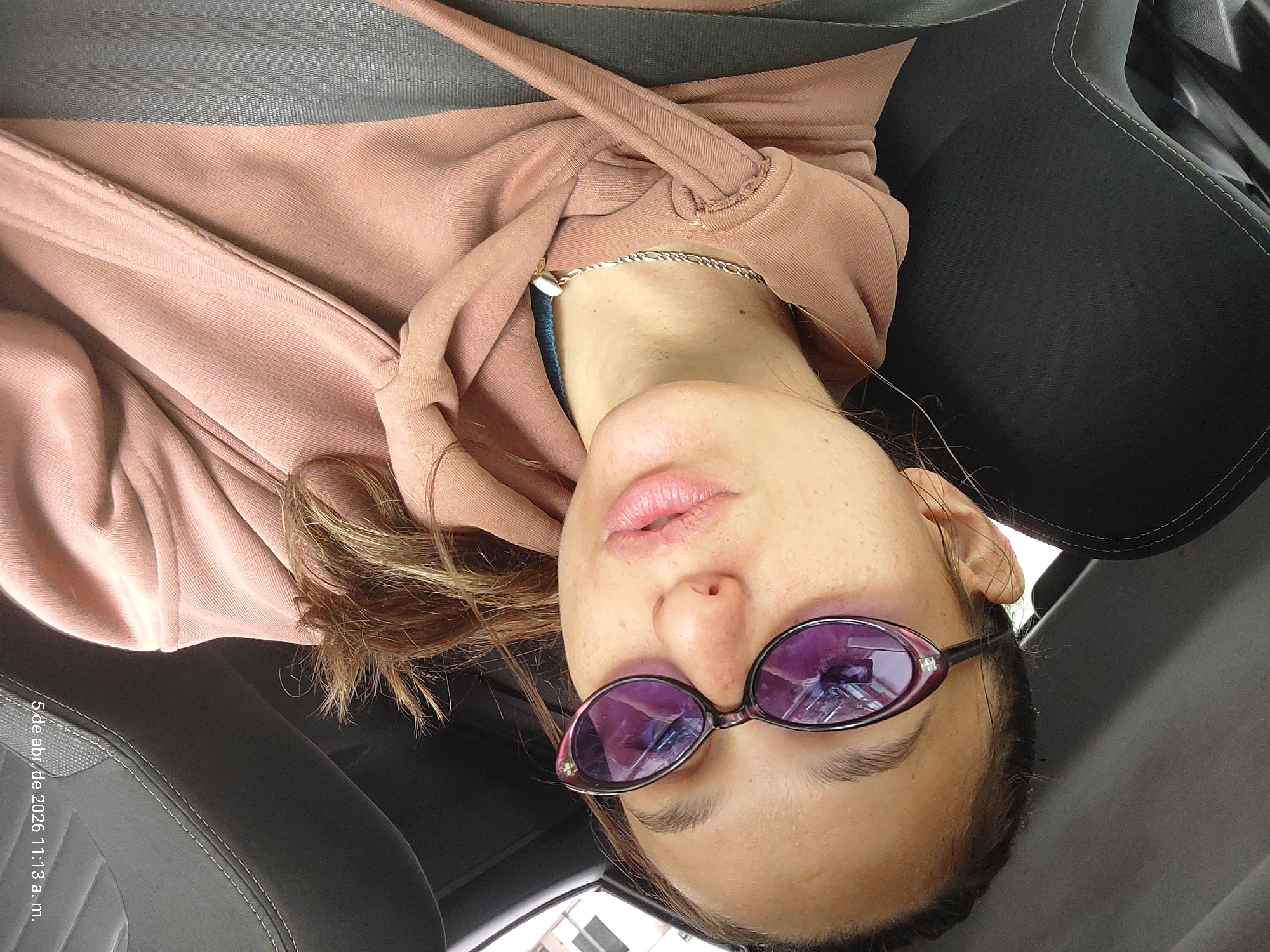 Woman in pink hoodie travels as car passenger in Buenos Aires