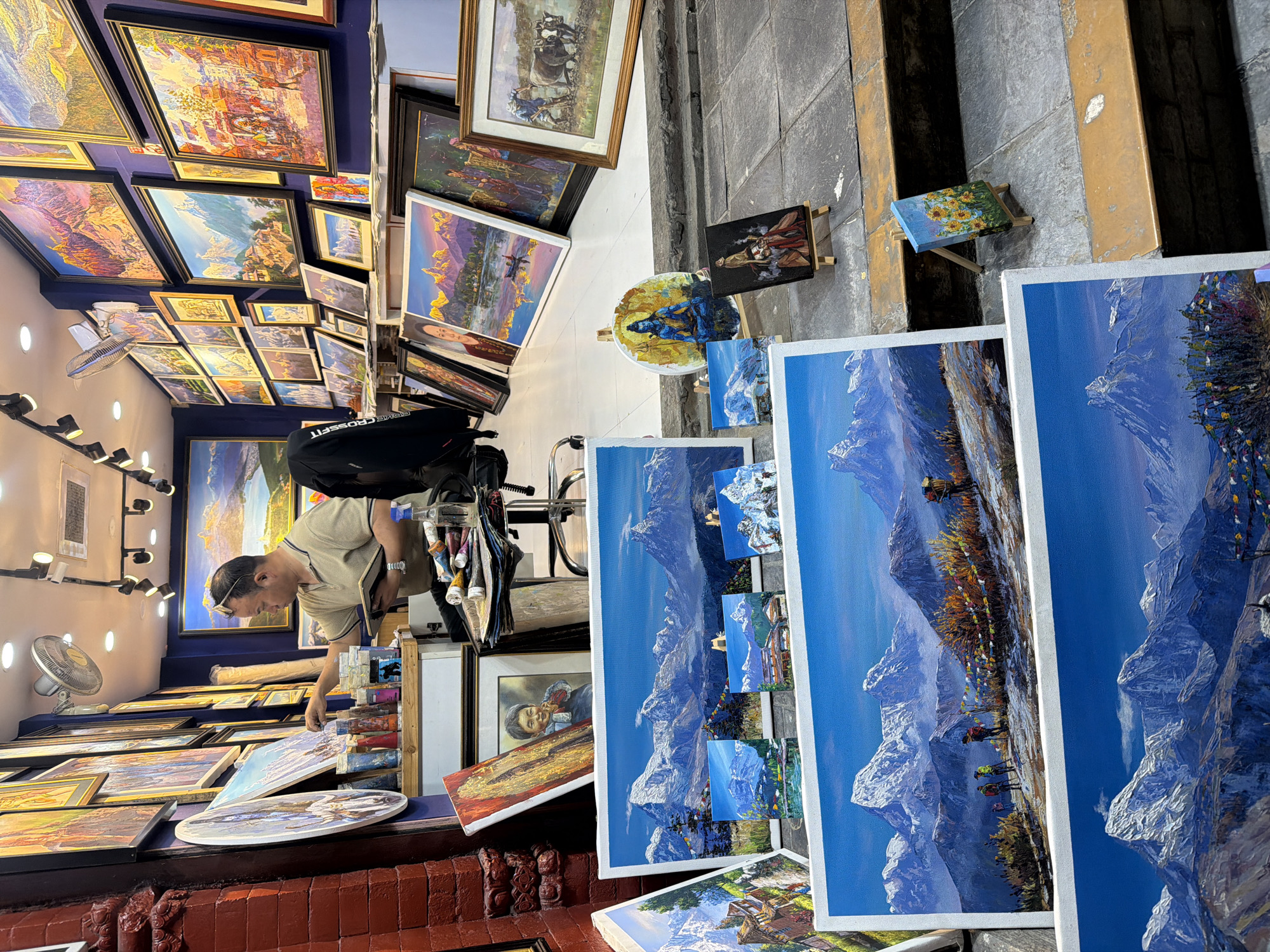 Man browses paintings at art shop in Pokhara