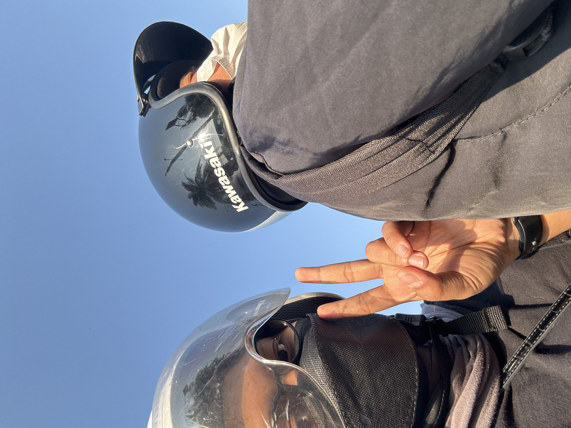 Motorcycle ride through West Jakarta streets with Transjakarta bus nearby