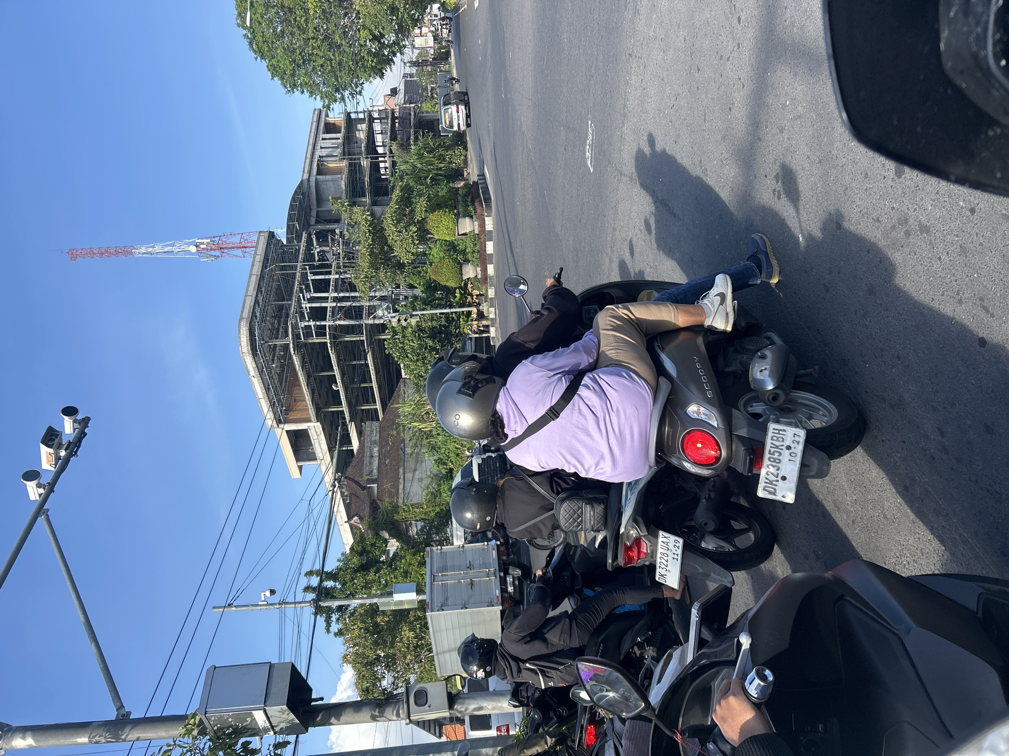 Midday traffic at a Denpasar intersection, police presence included