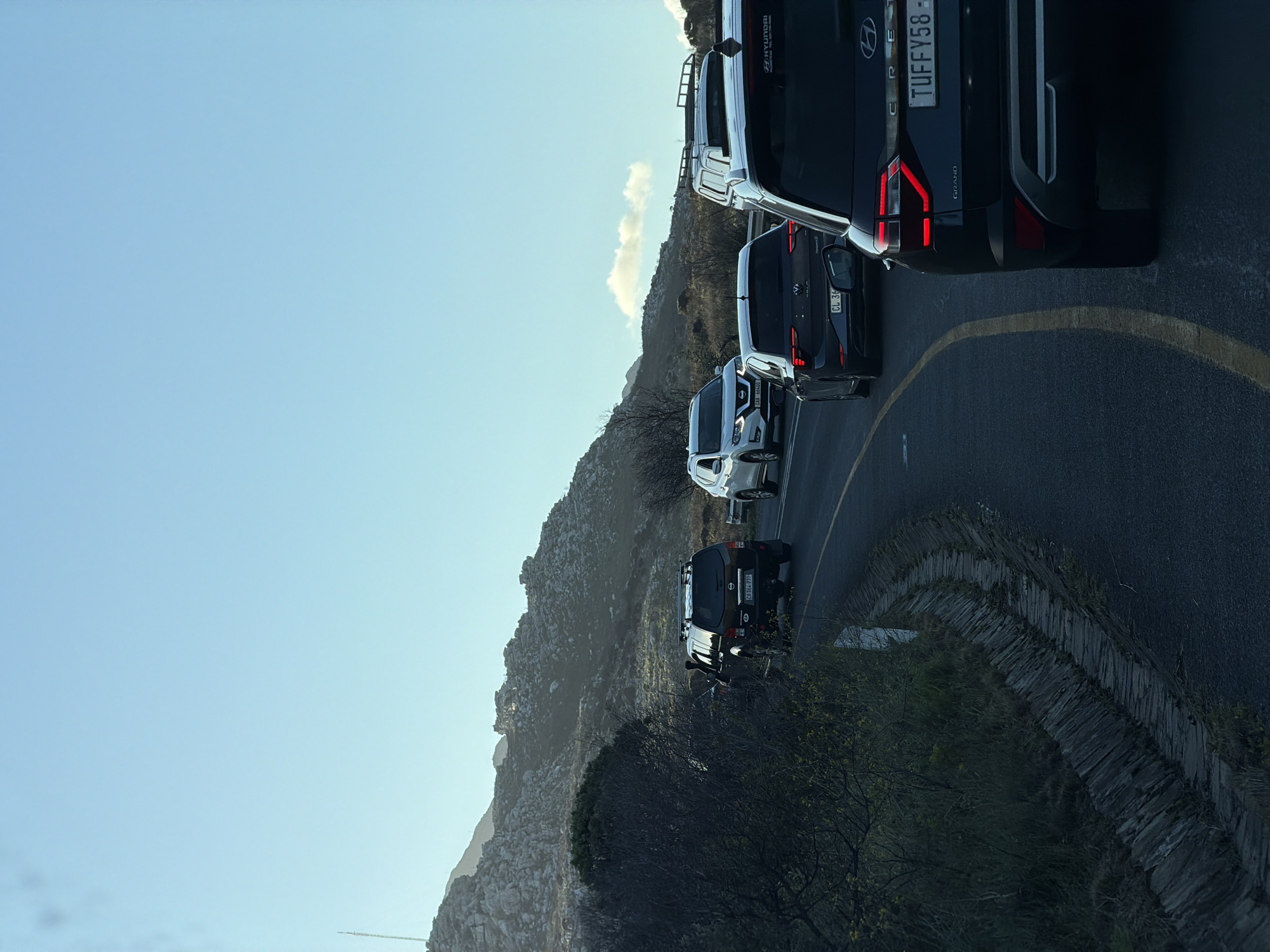 Vehicles queue along mountain road in Noordhoek