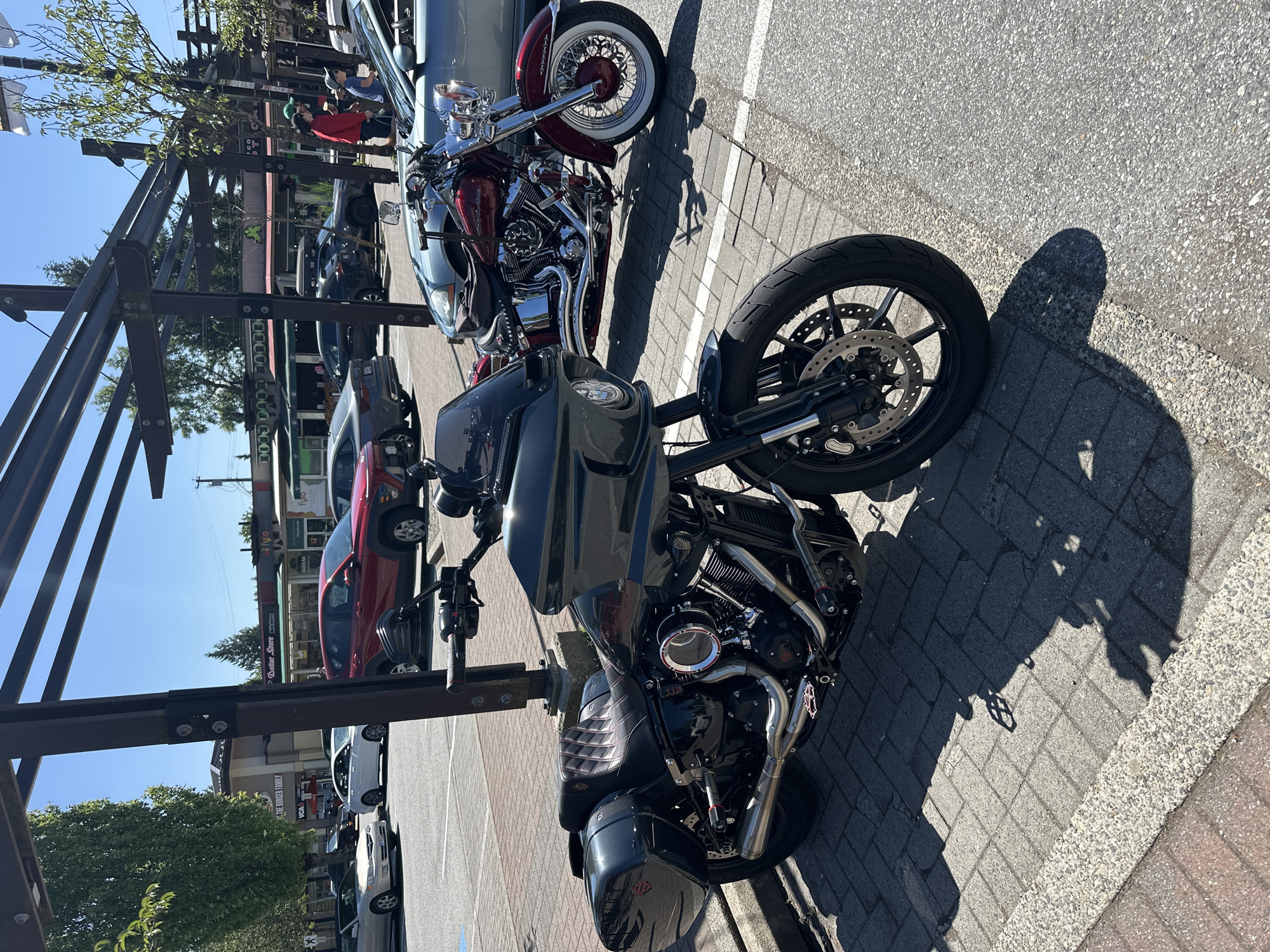 Two Harley-Davidson motorcycles parked on Coquitlam brick sidewalk