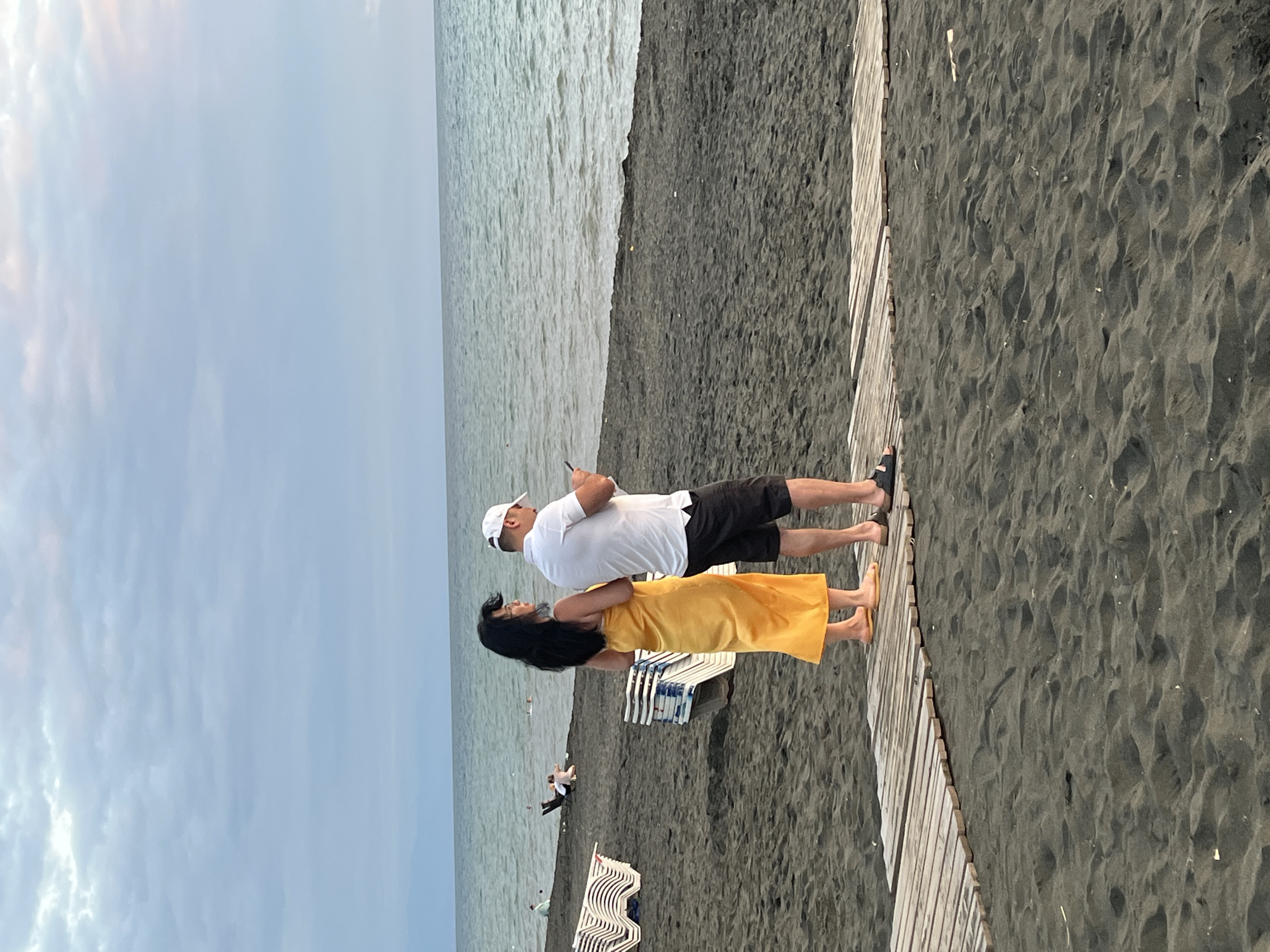 Sunset stroll along Ureki's black sand beach by bicycle