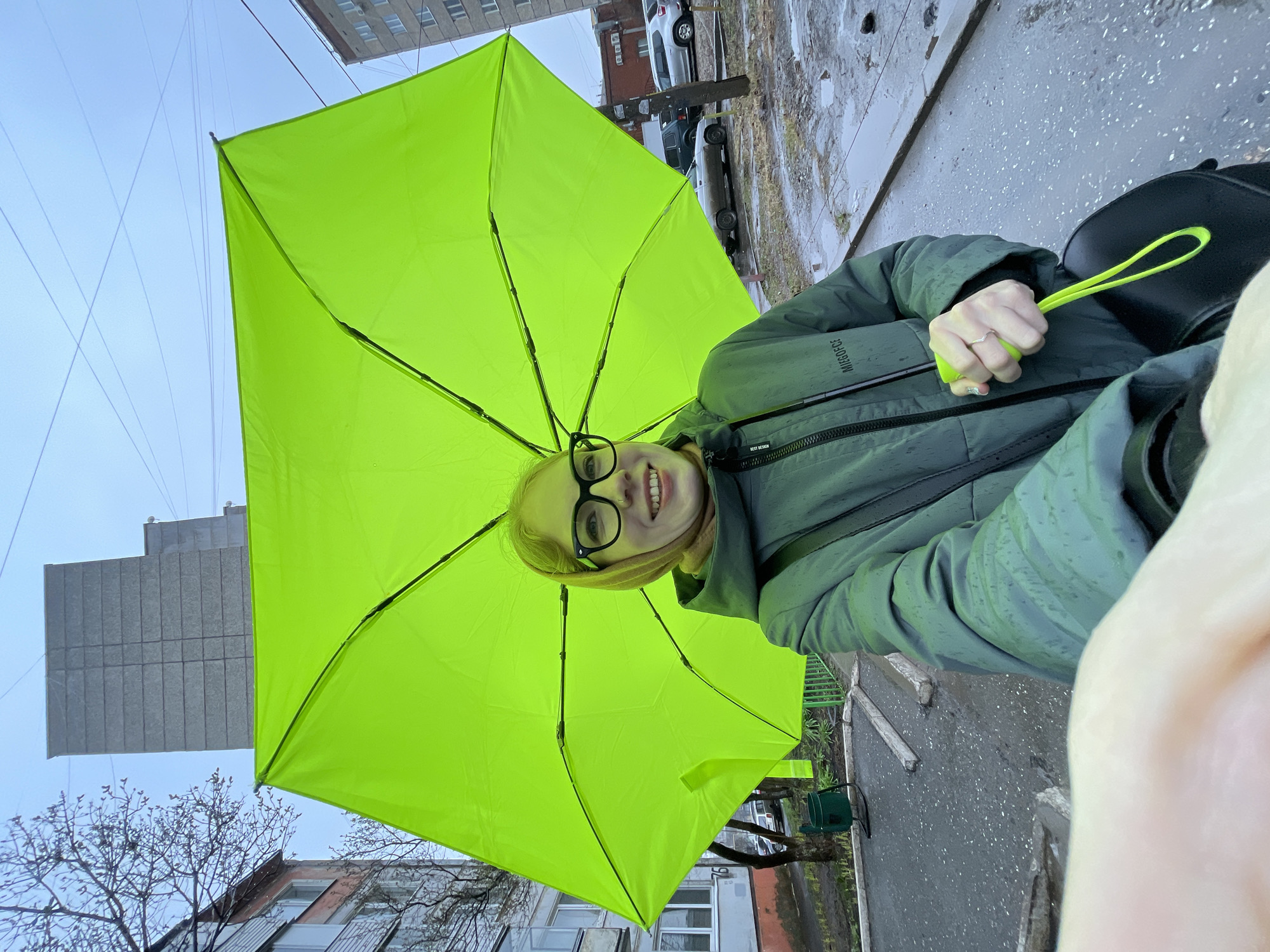 Woman with green umbrella photographed on rainy Izhevsk streets