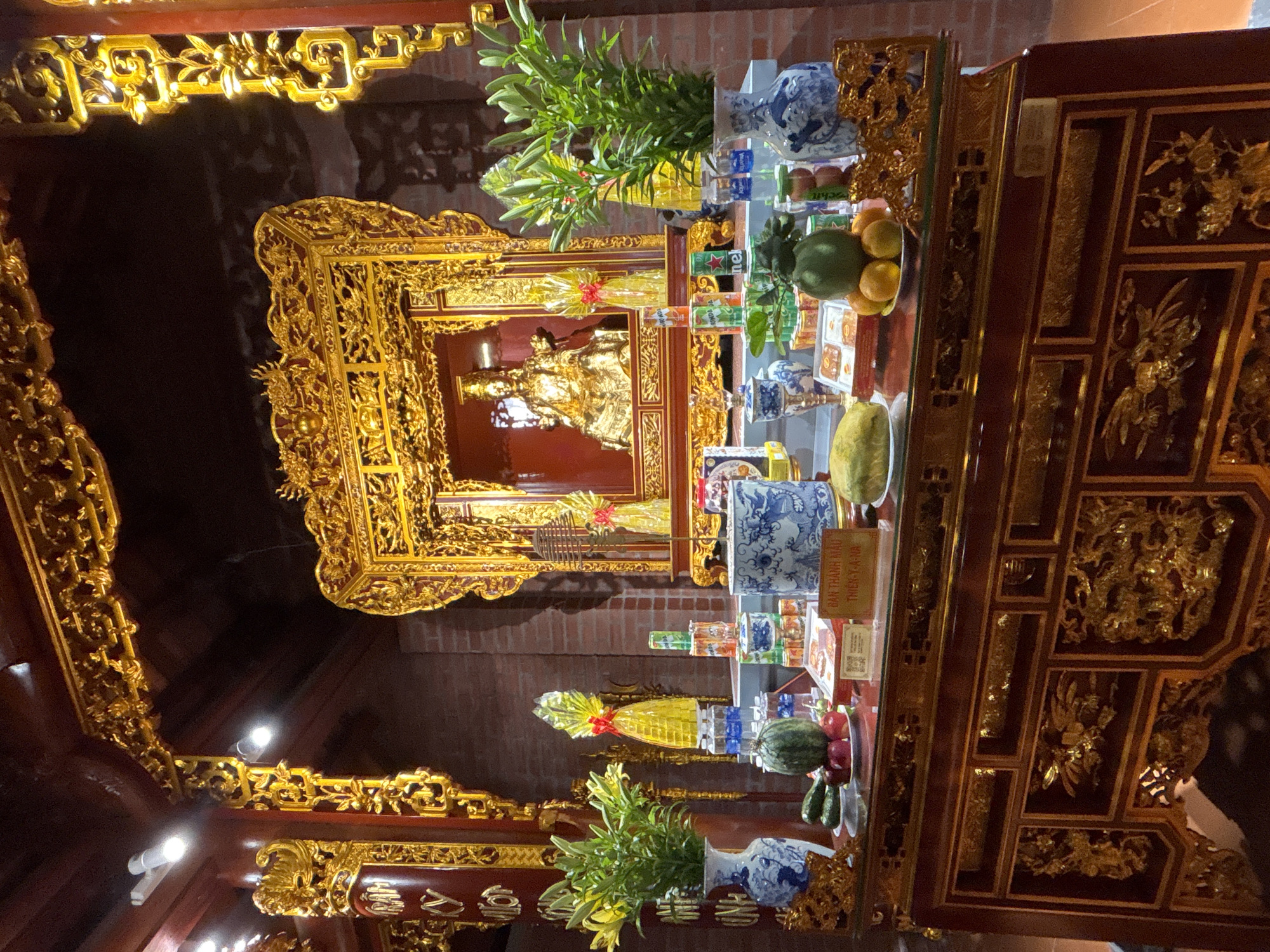 Inside a Vietnamese Buddhist temple, altars dressed with offerings
