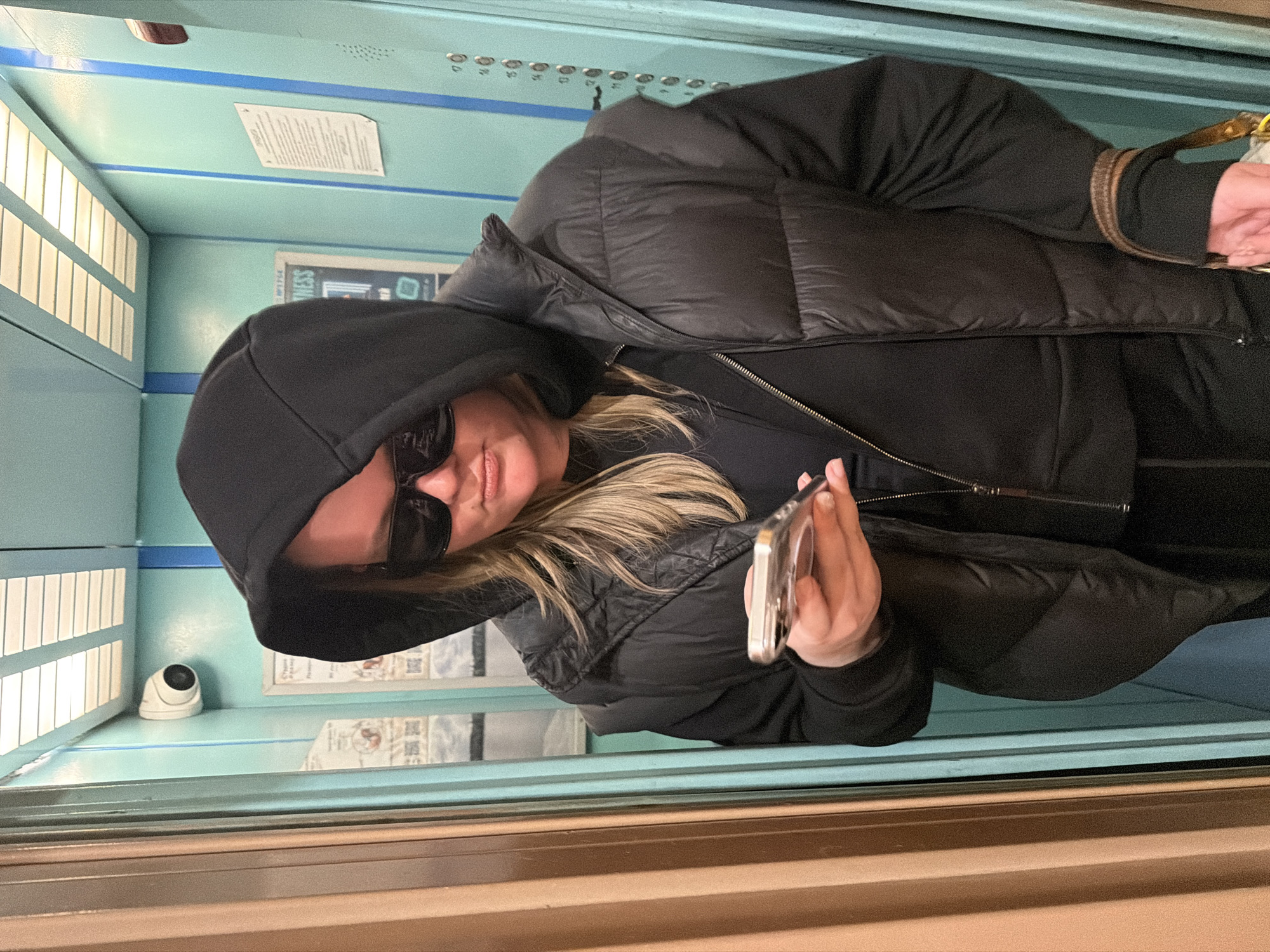 Woman with phone rides elevator in Saint Petersburg