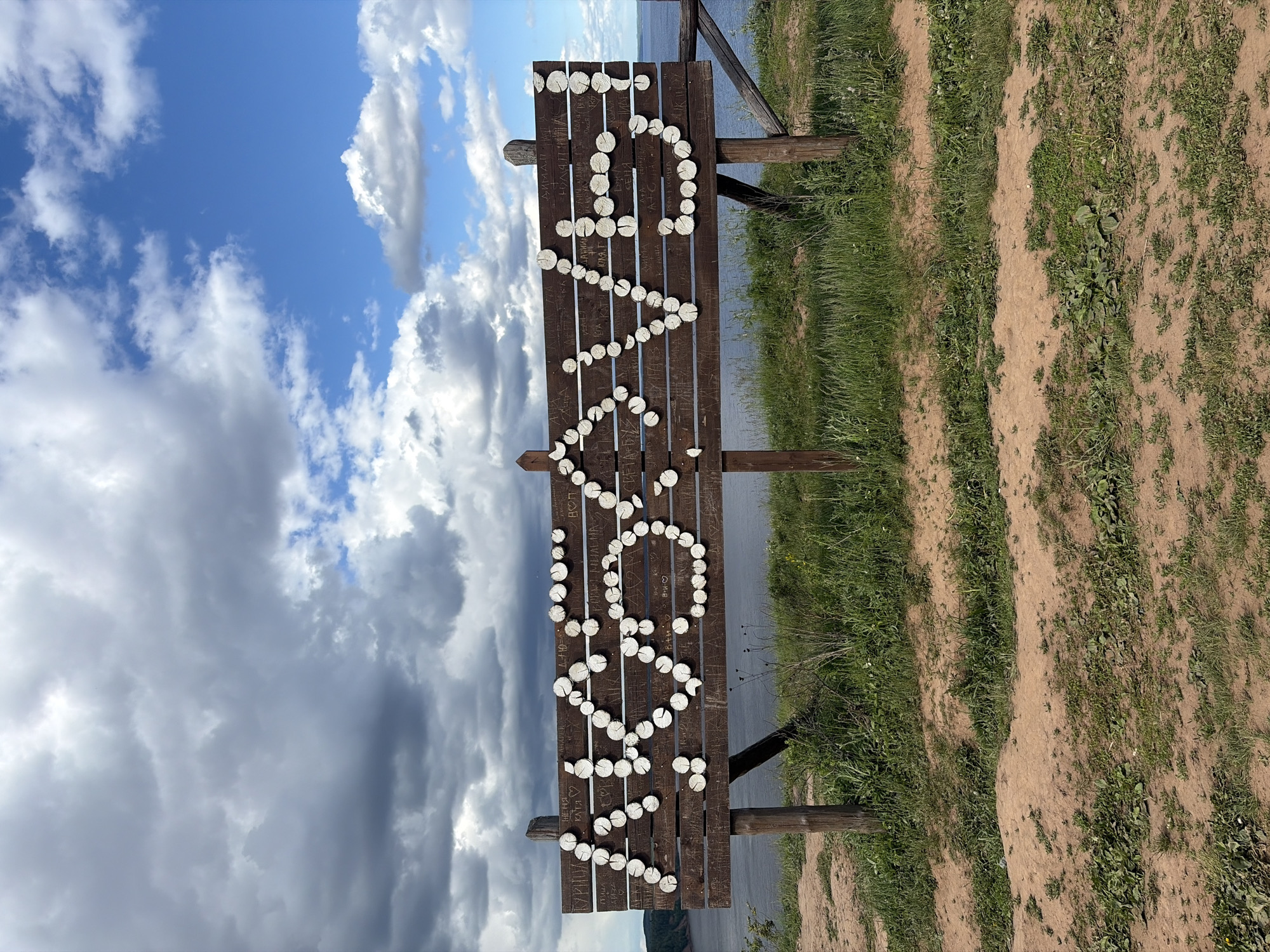 Scenic waterfront views and wooden signage captured in Костоваты