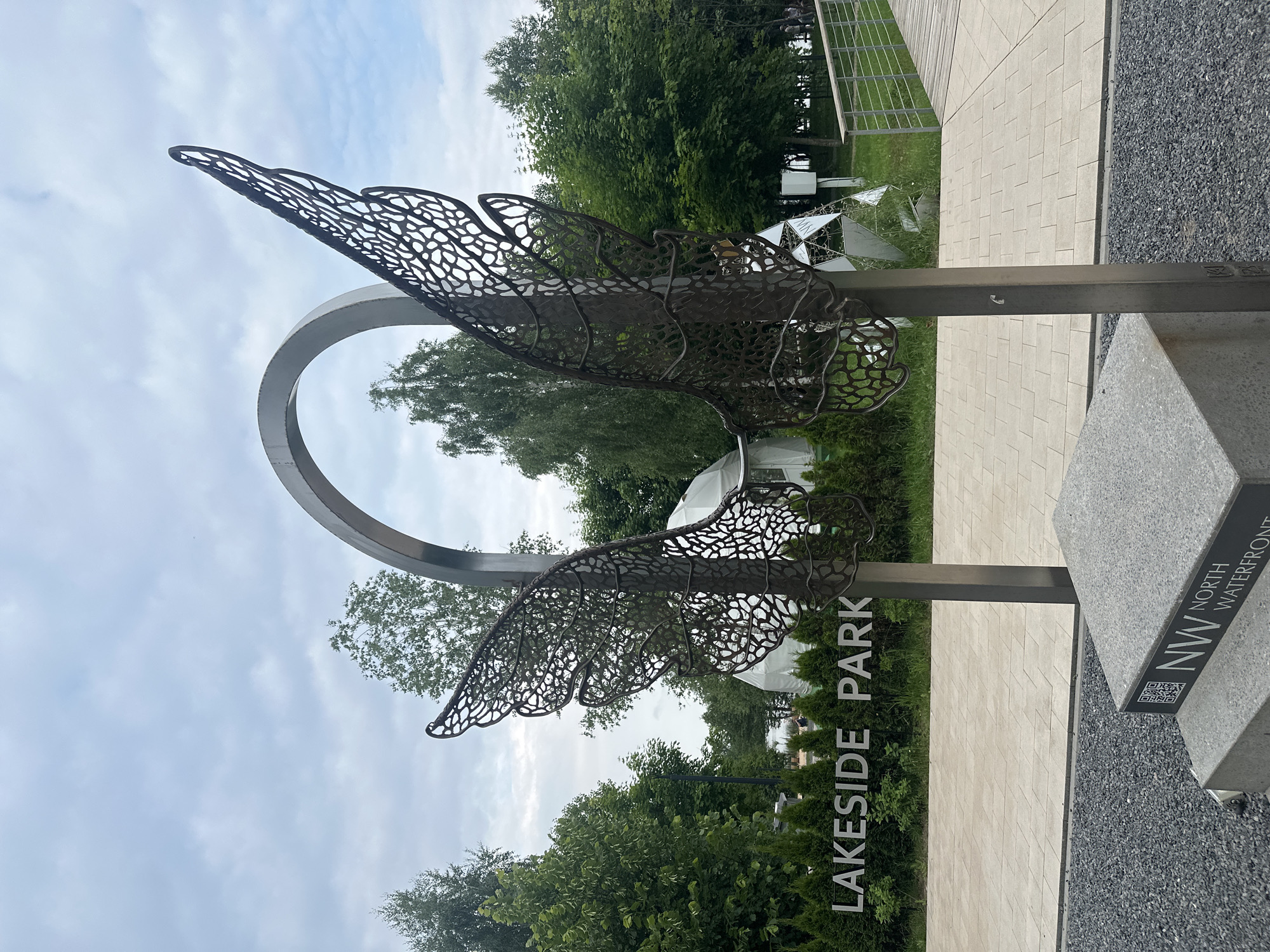 Visitor documents sculptures and wildlife during Minsk park afternoon stroll