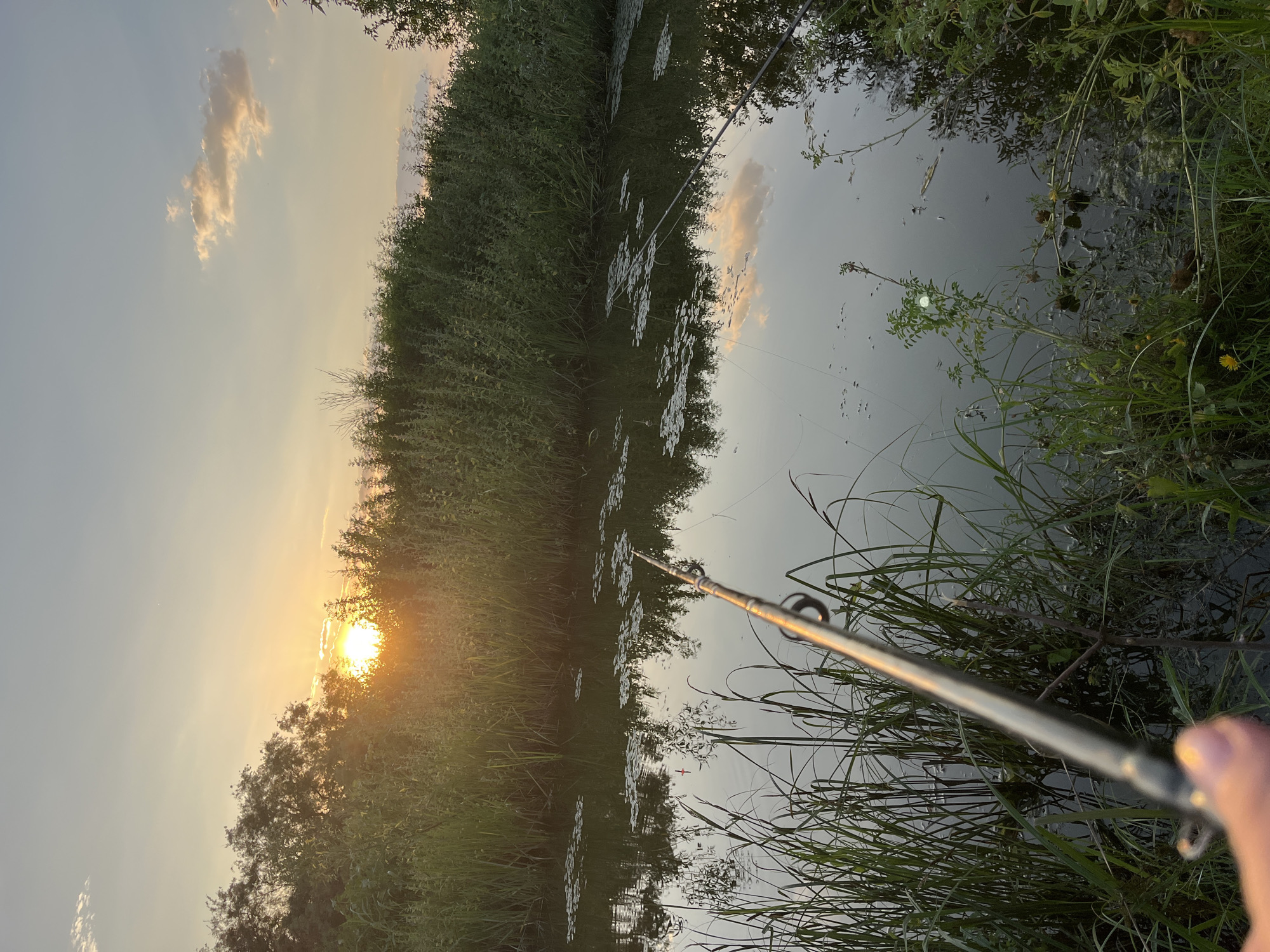 Fishing at sunset on a quiet Russian canal