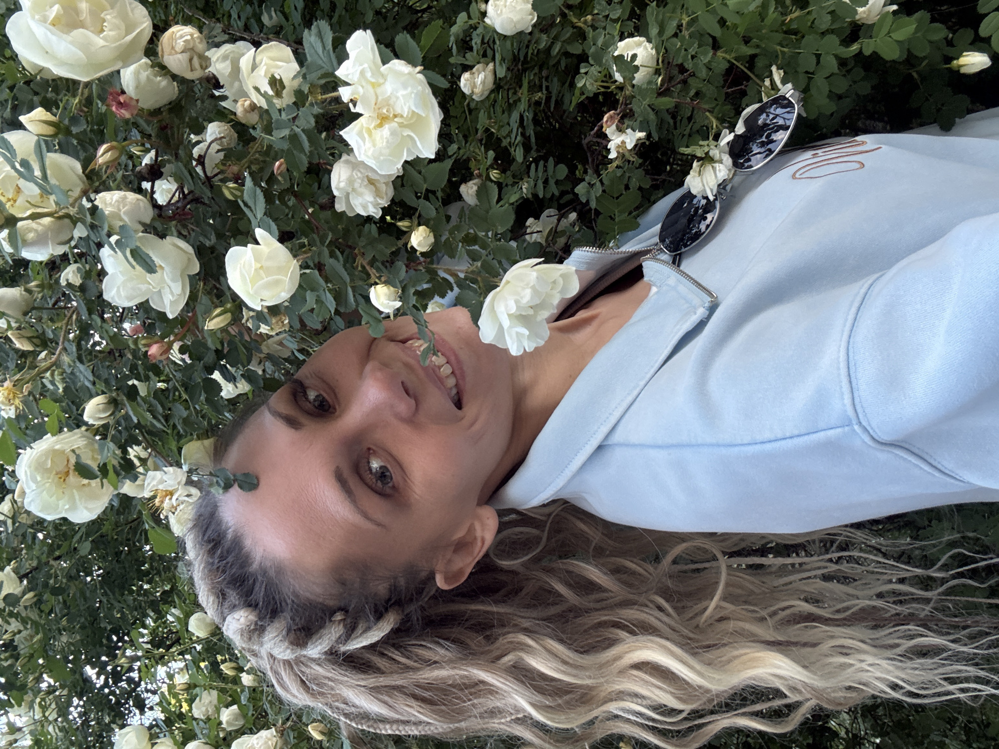 Woman travels between Russian towns, poses near roses and waves from boat
