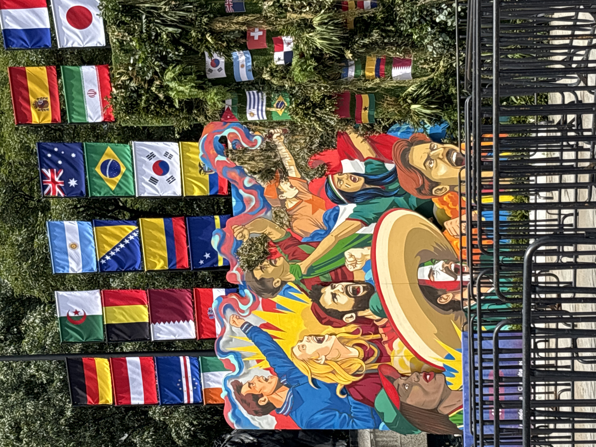Public art, flags, and skyline along a Mexico City street