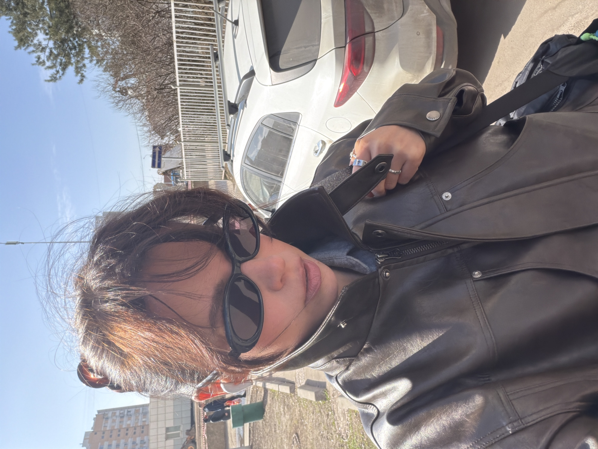 Woman takes outdoor selfie in bright Moscow sunlight