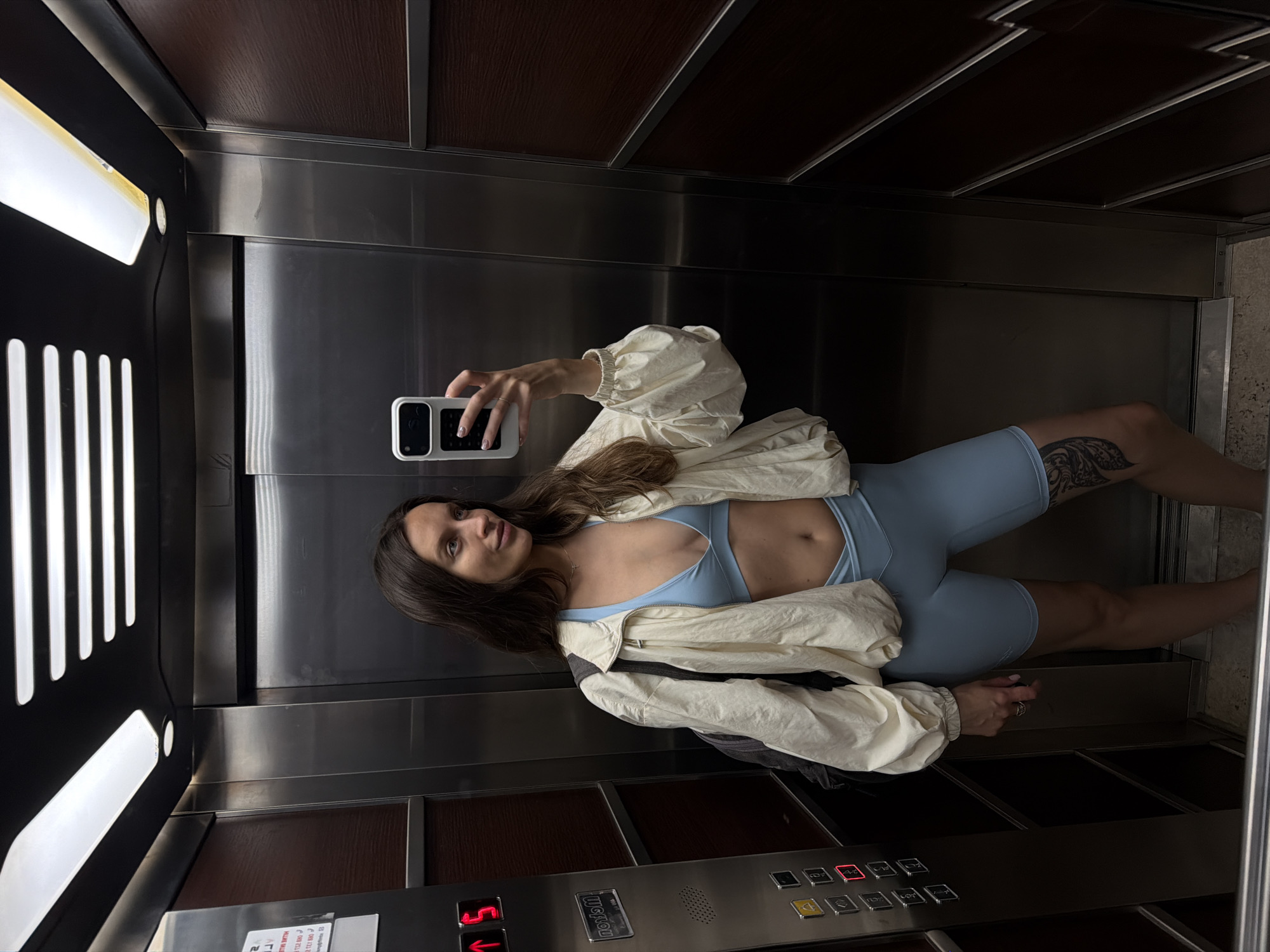 Woman Takes Selfie in Elevator Wearing Athletic Wear
