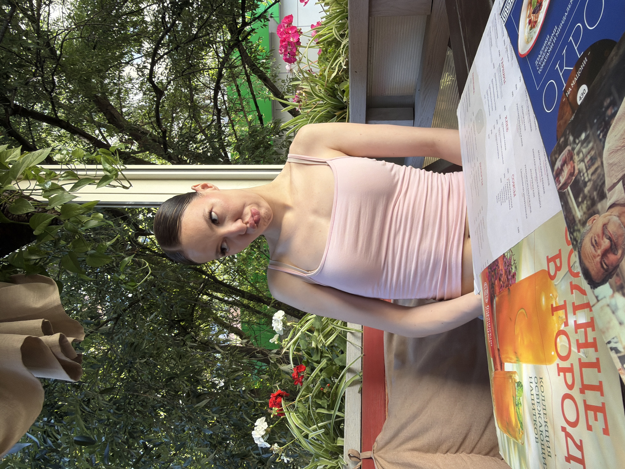 Pouty pose at an outdoor table stacked with menus