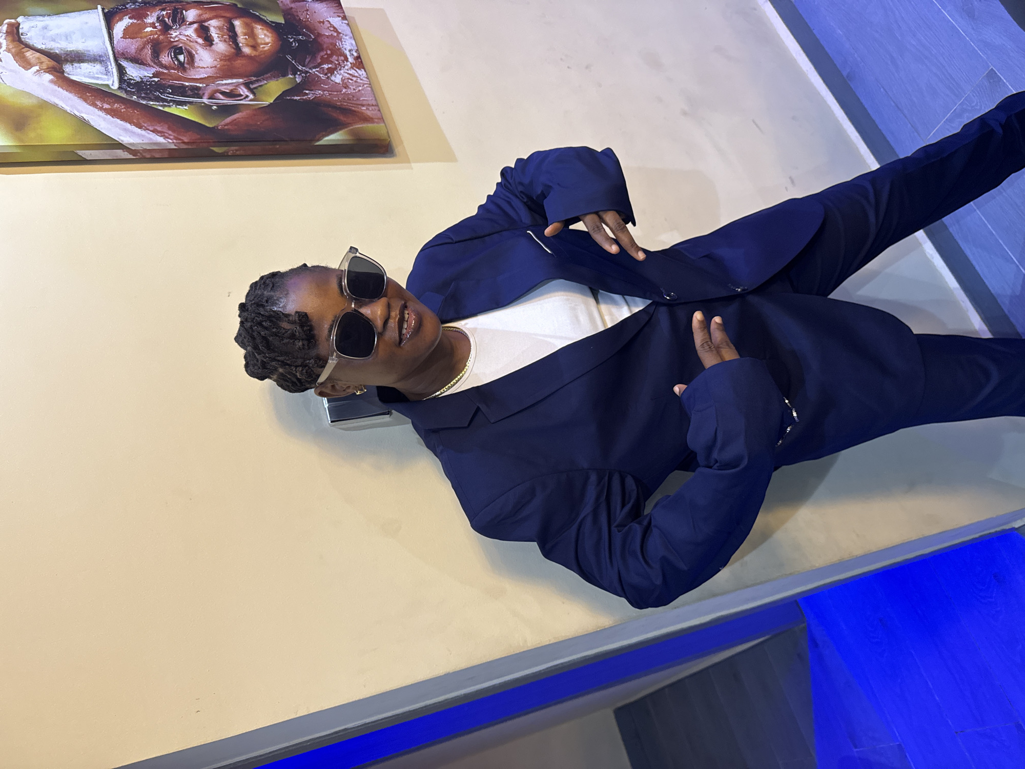 Woman in navy suit poses with boxes in Ajara