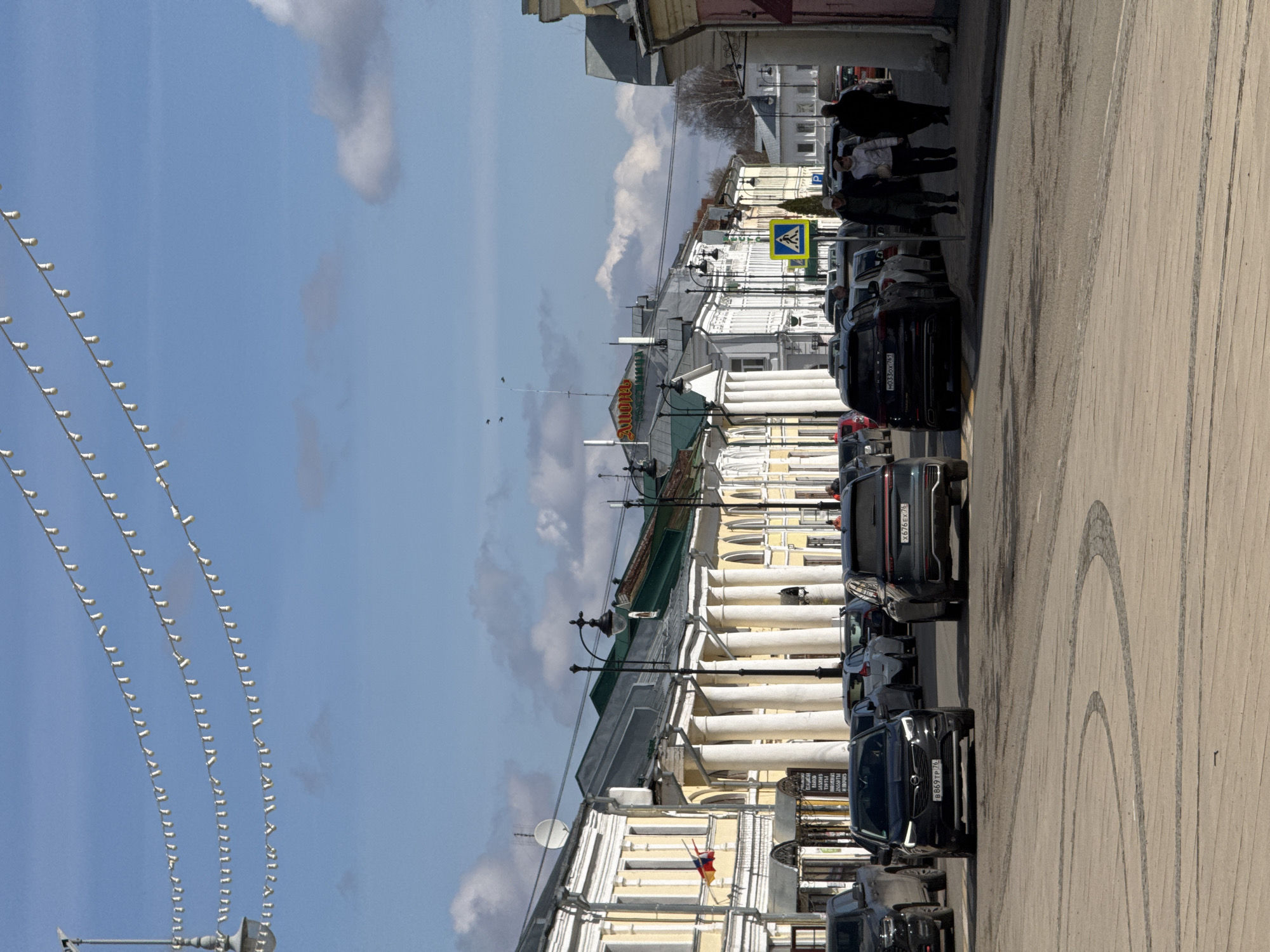 Woman photographs historic street scene in Novo-Nikol'skoe
