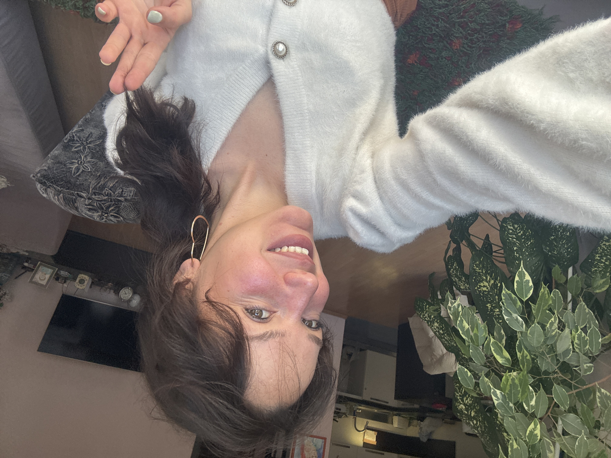 Woman takes selfies in white cardigan in Burgas apartment
