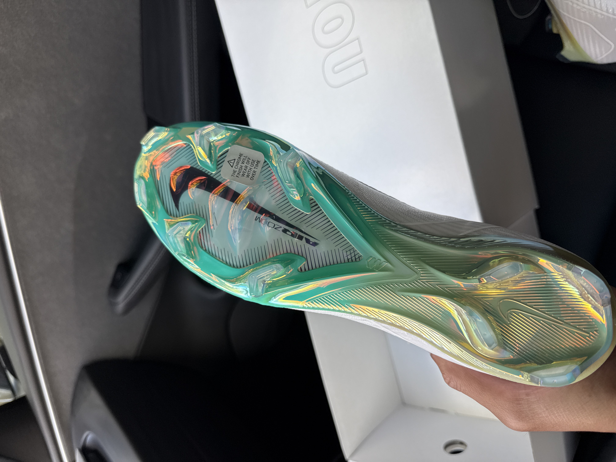 Person showcases new soccer cleats inside Los Angeles vehicle