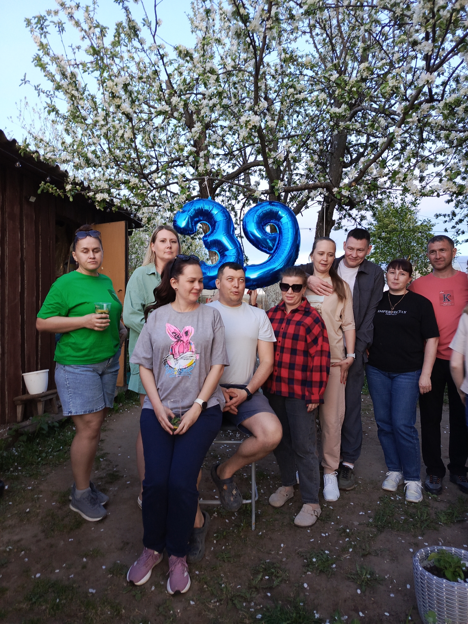 Ten people gather in backyard, location unknown