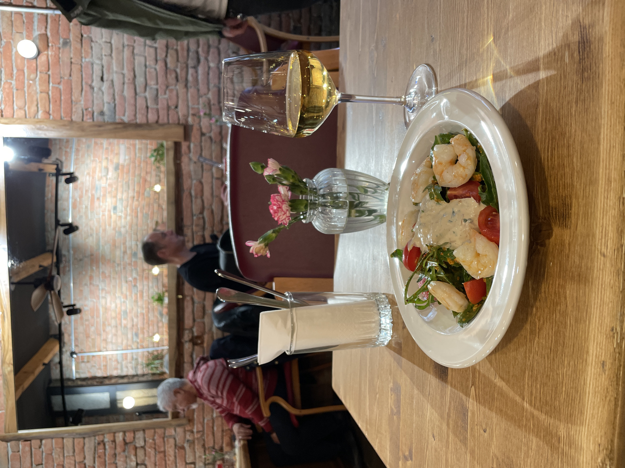 Diner enjoys shrimp salad and white wine in Tbilisi