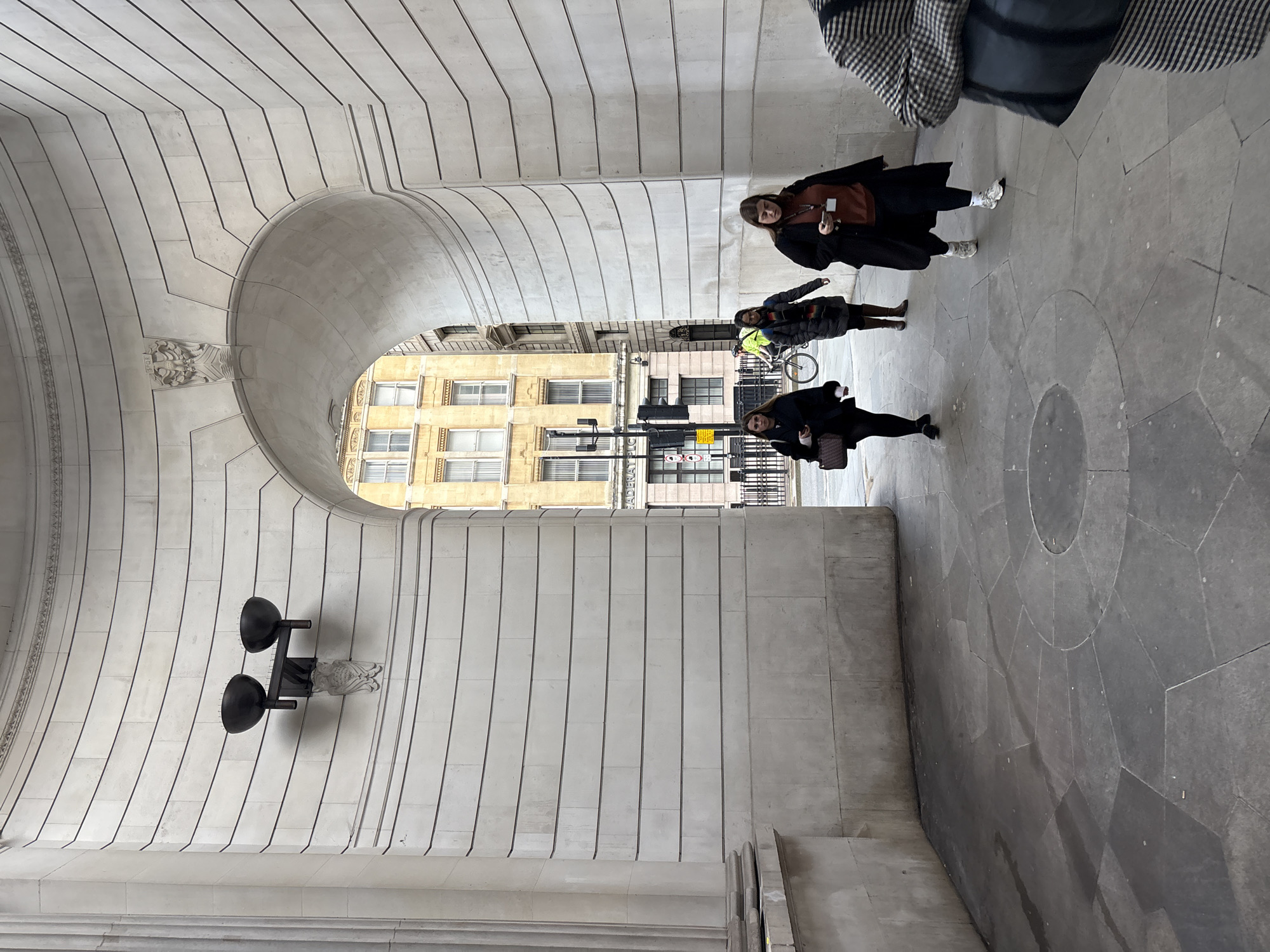 Pedestrians navigate historic archway near London's Bank Station