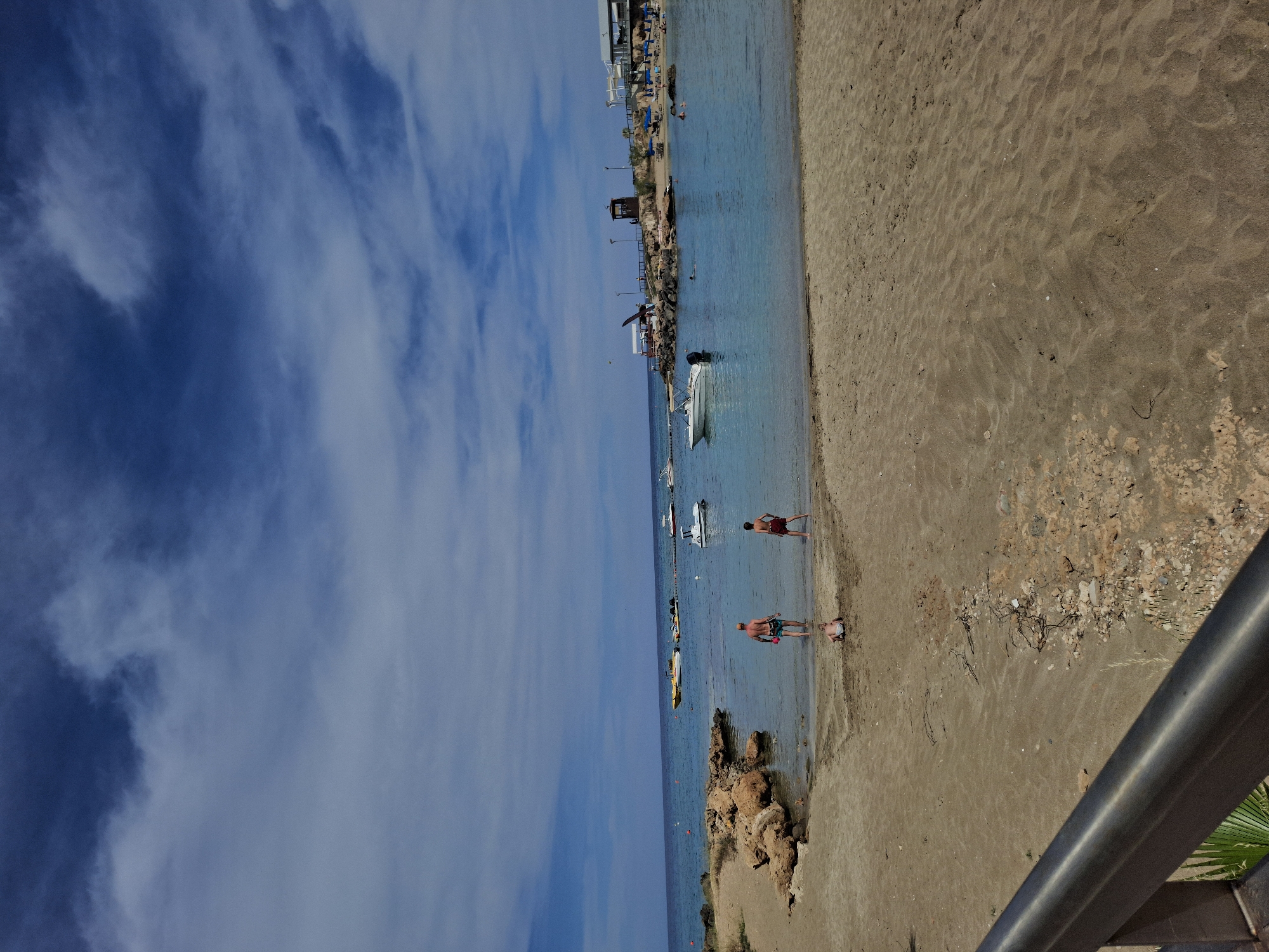 Two beachgoers wade in Fig Tree Bay waters, Cyprus