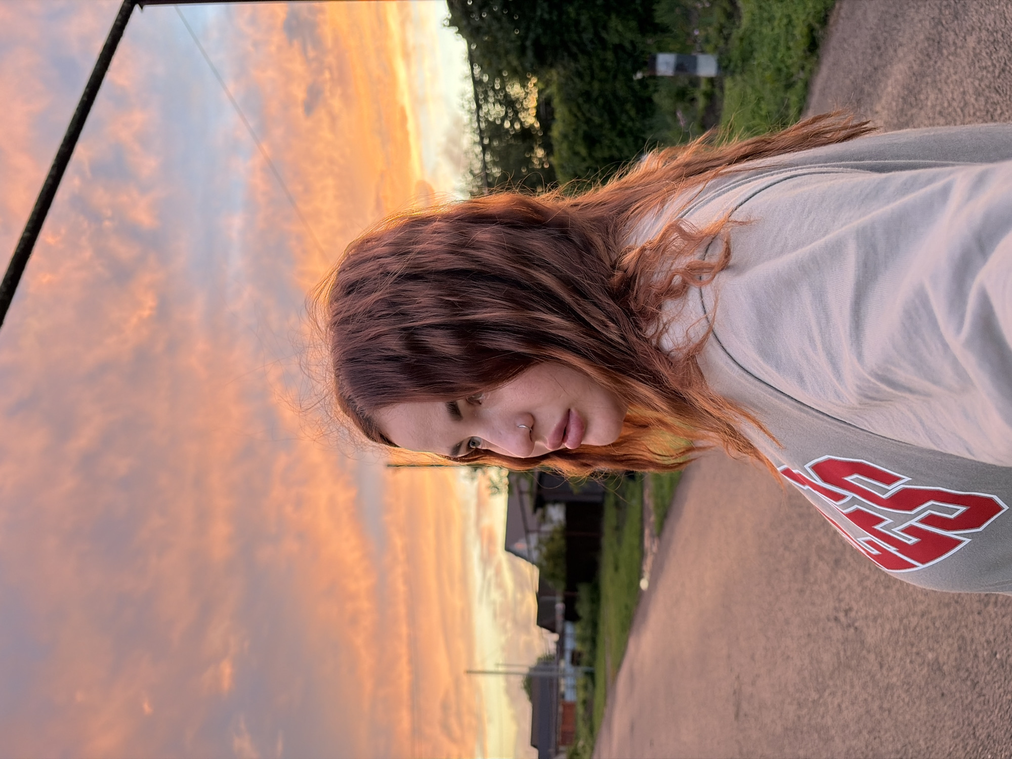 Woman photographed on urban street during sunset hours