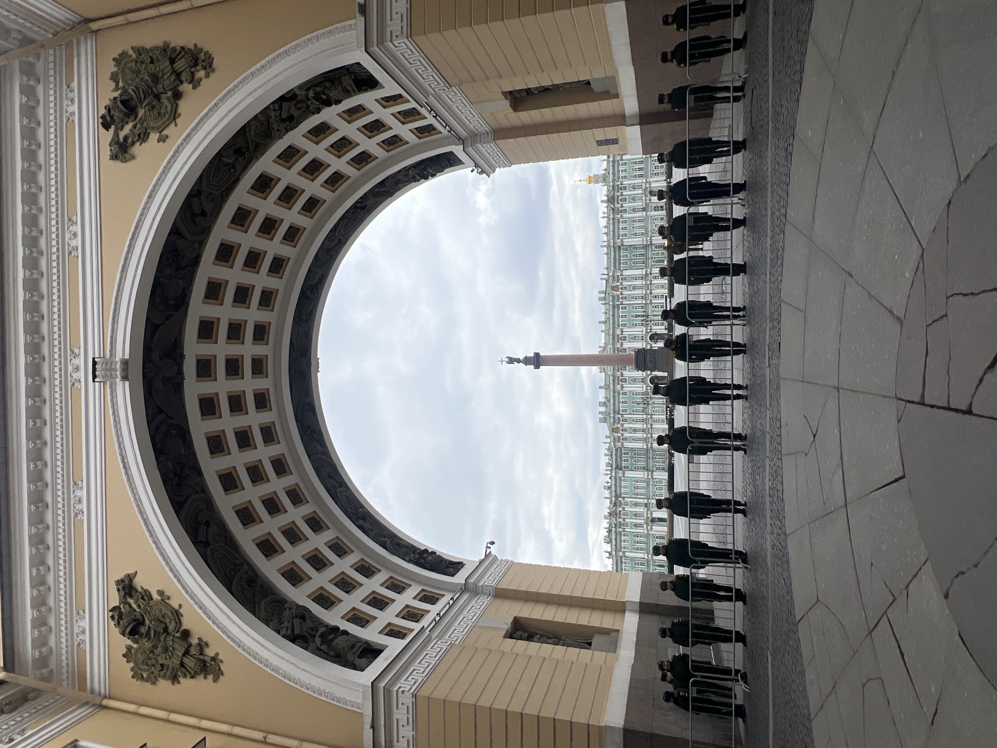 Tourist documents Palace Square architecture during overcast afternoon