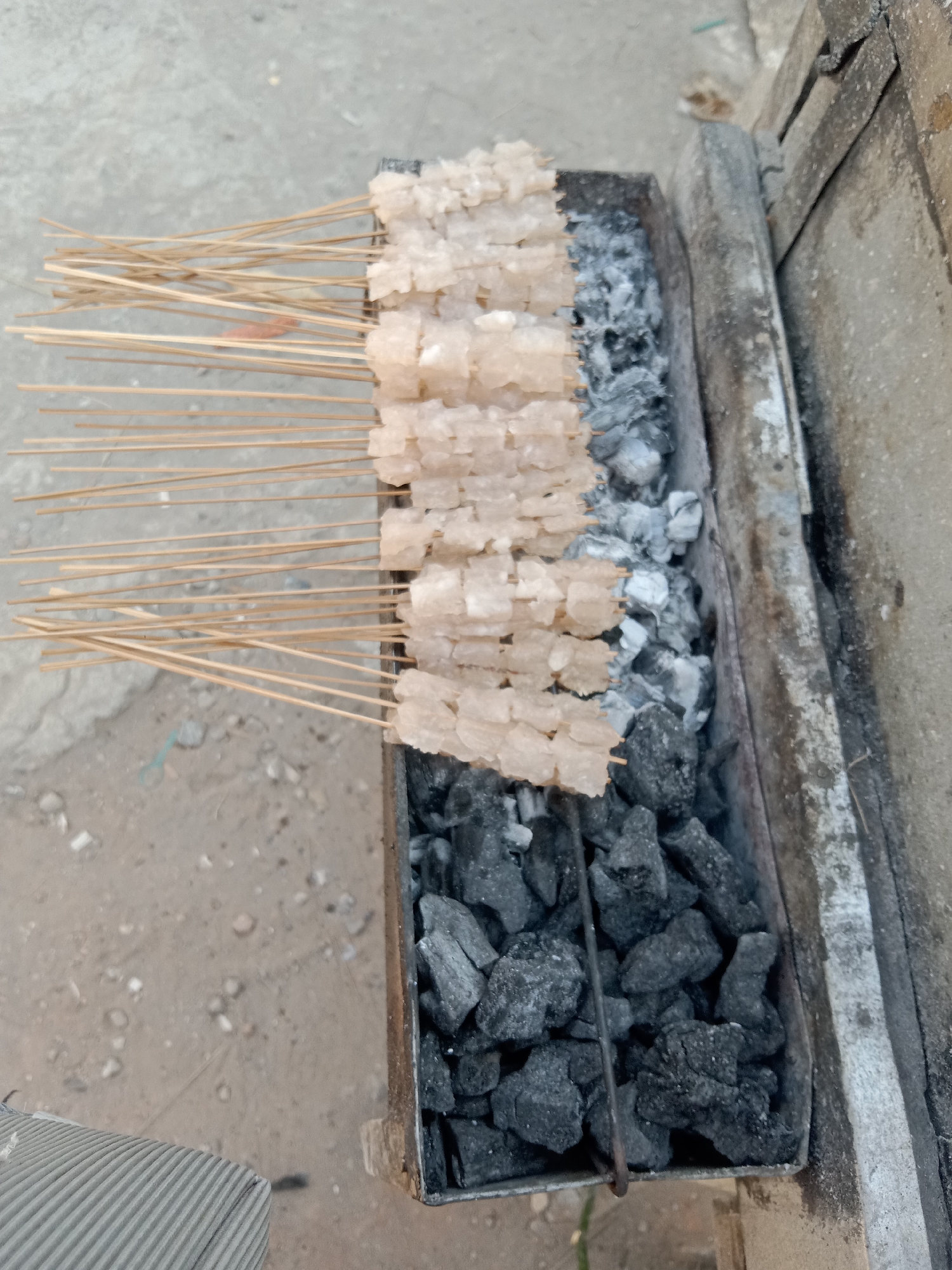 Street grilling and a roadside vendor near a mosque in Sugihwaras