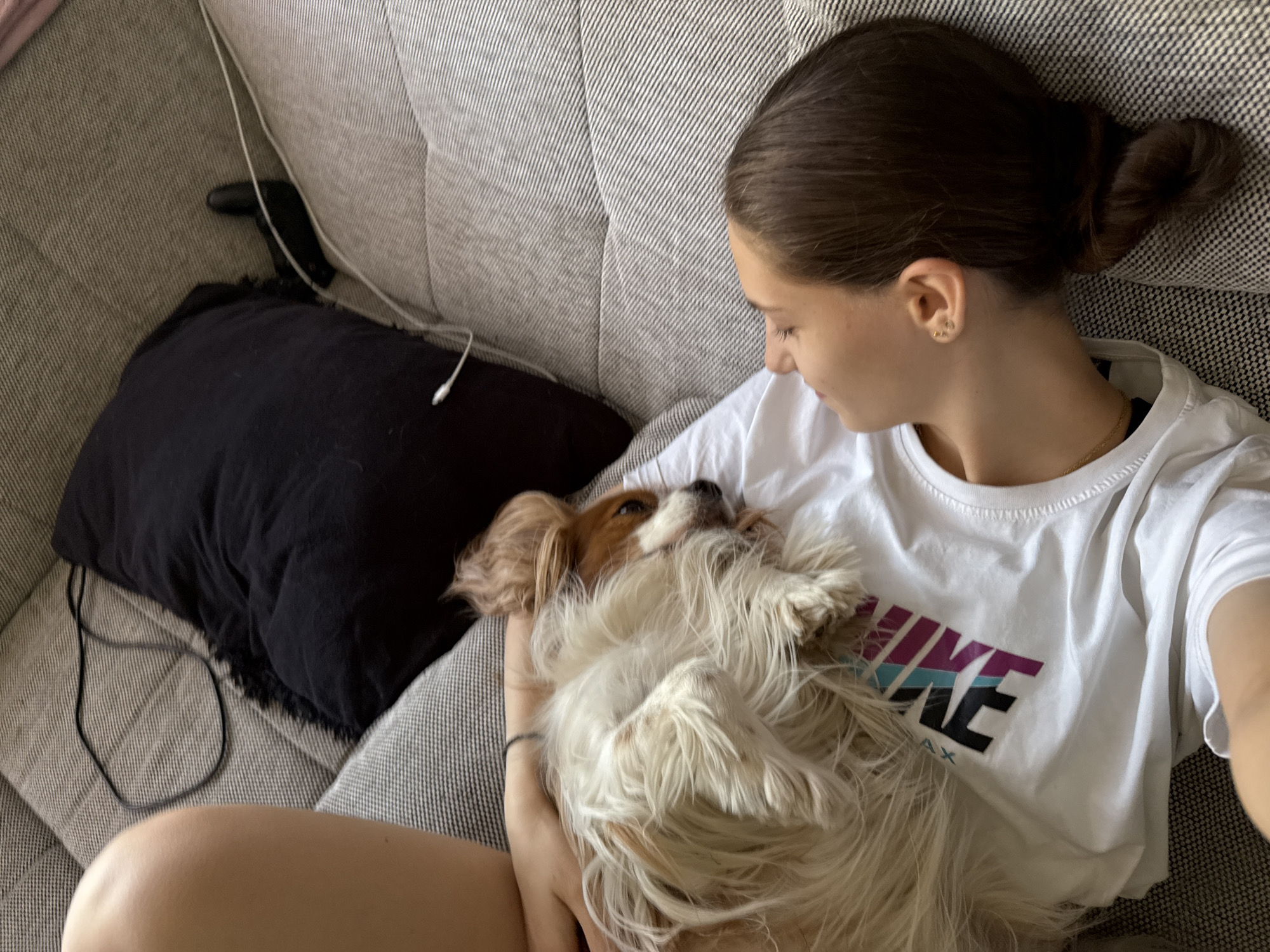 Woman relaxes with Cavalier King Charles Spaniel on Sofia couch
