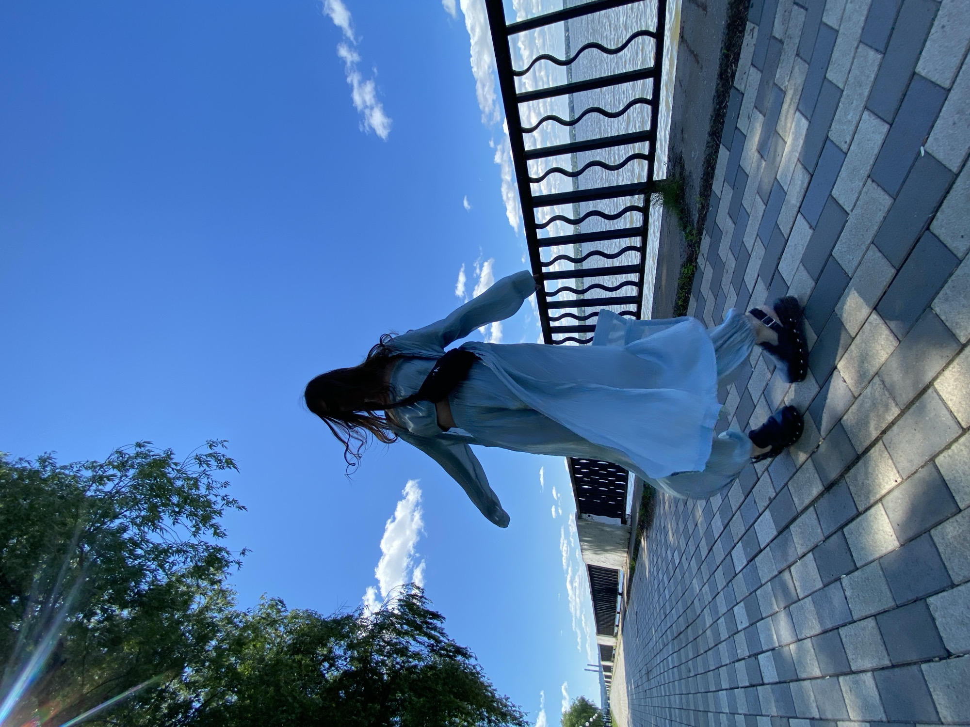 Woman in light blue outfit spotted outdoors in sunny weather