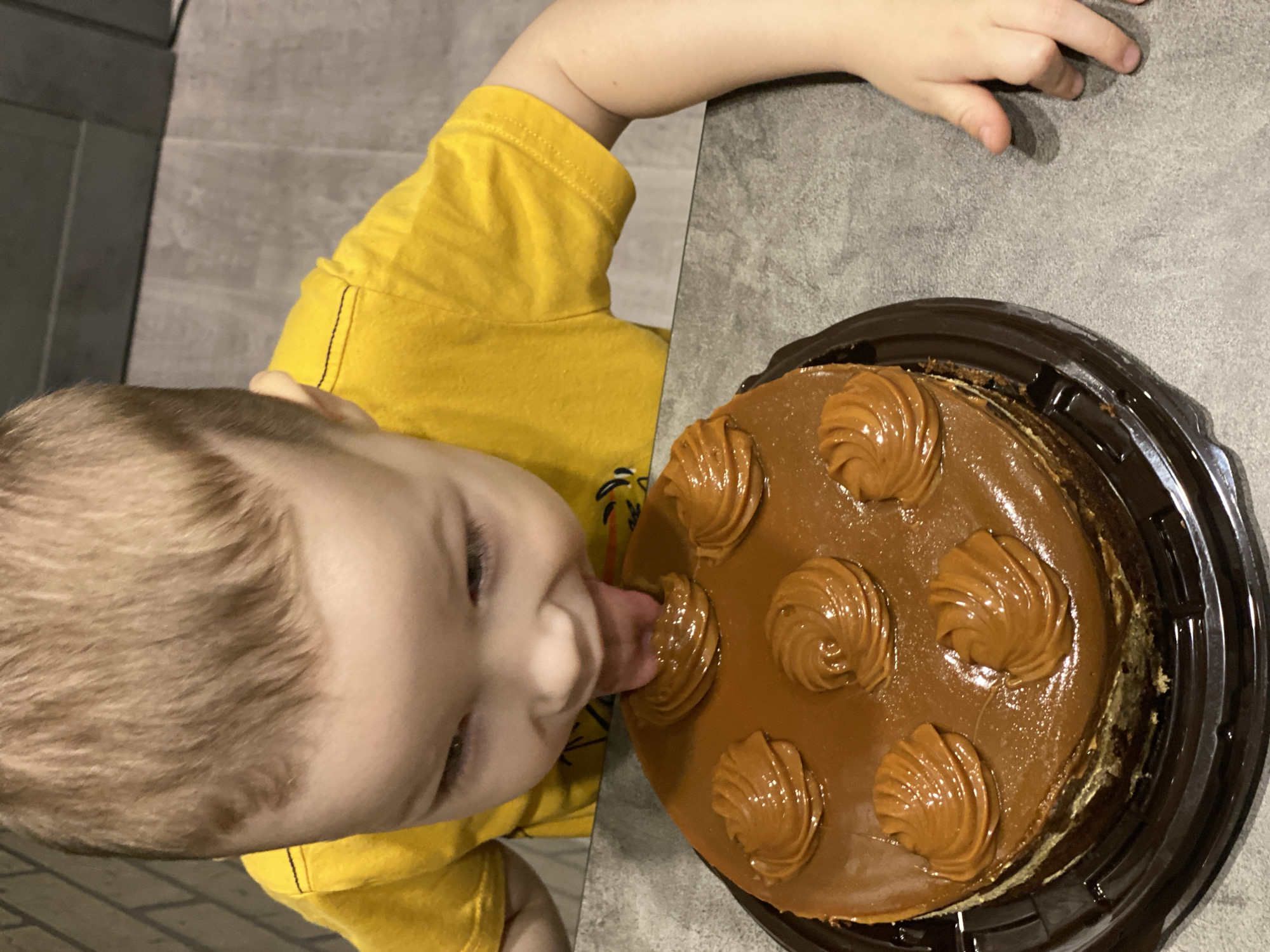 Child enjoys caramel cake during sunny afternoon in Sochi