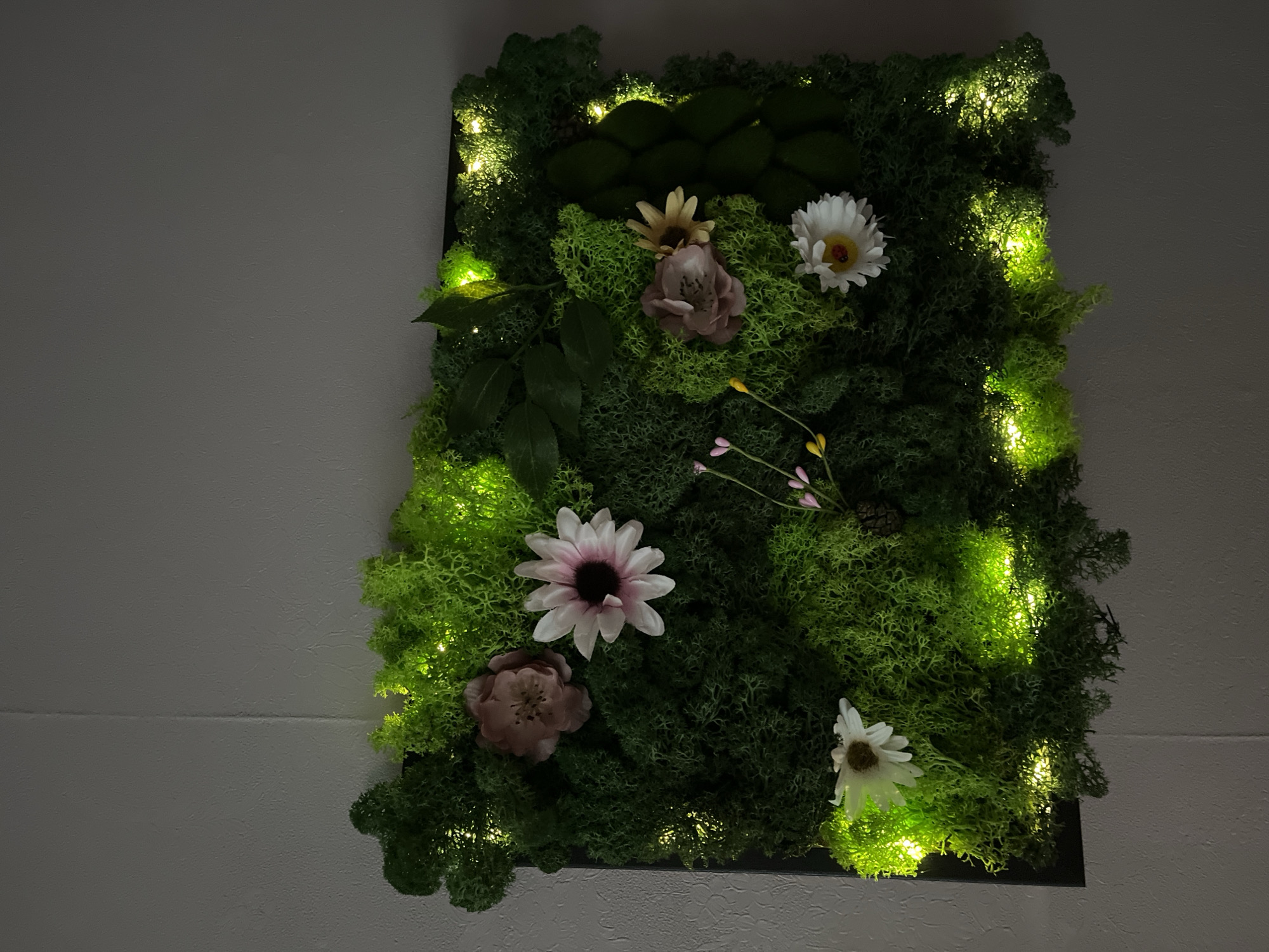 Decorative moss wall art with artificial flowers spotted in Liepaja