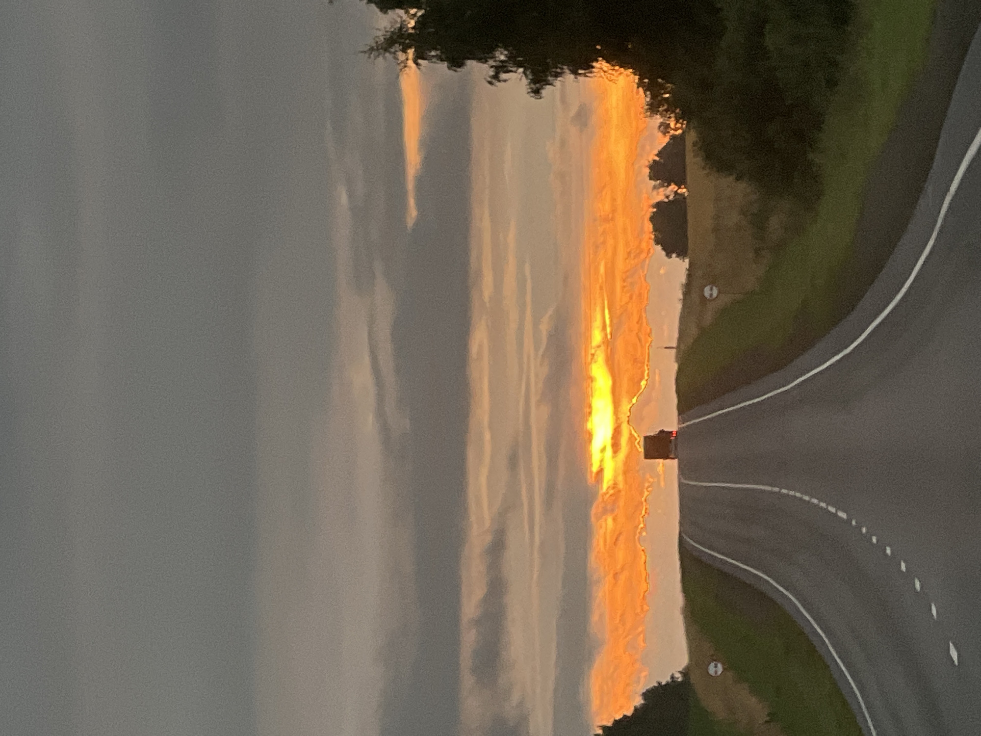 Dusk drive on a rural Russian highway under a fiery sunset
