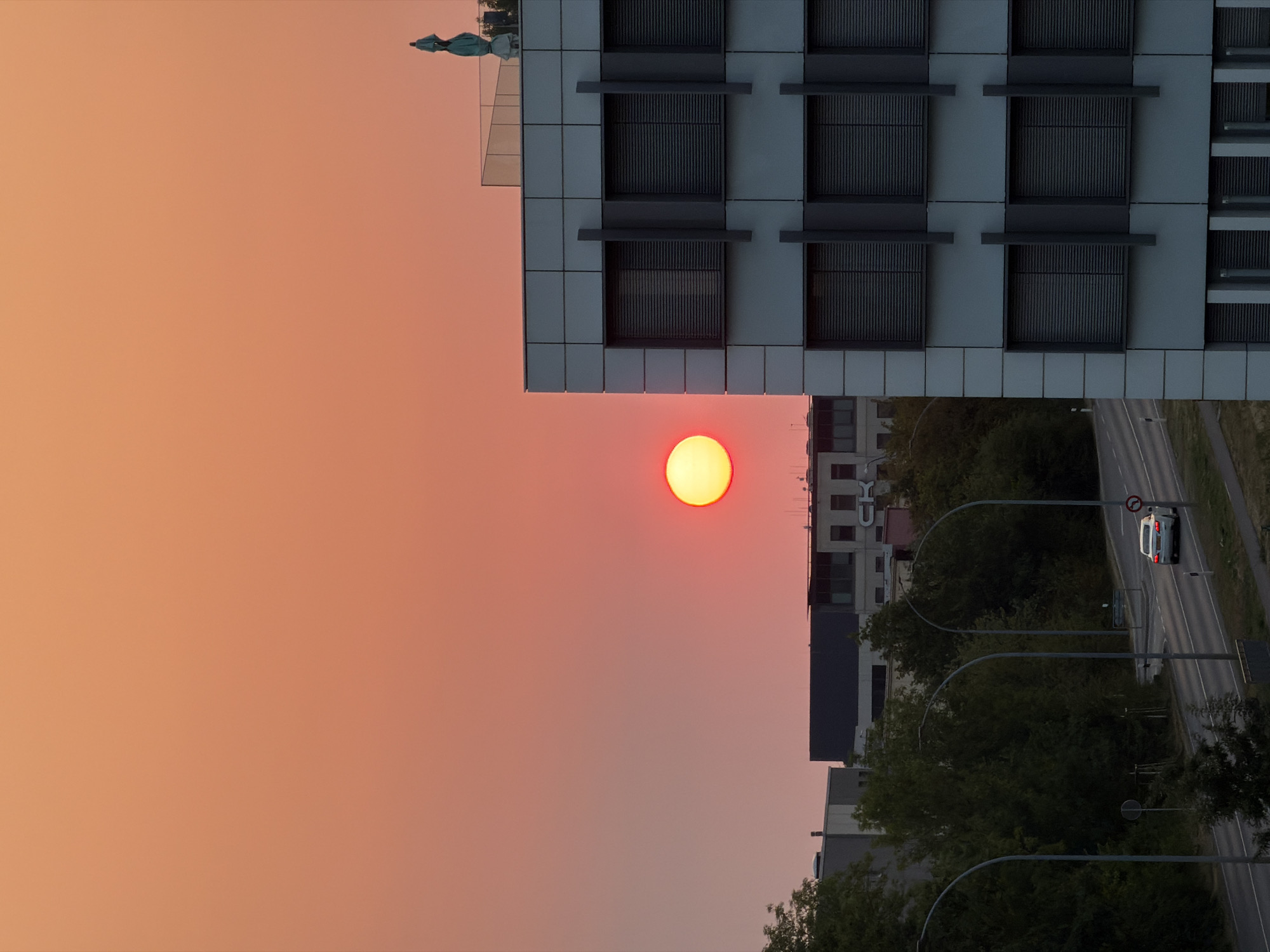 Sunrise over Leudelange's office district, with a departing jet
