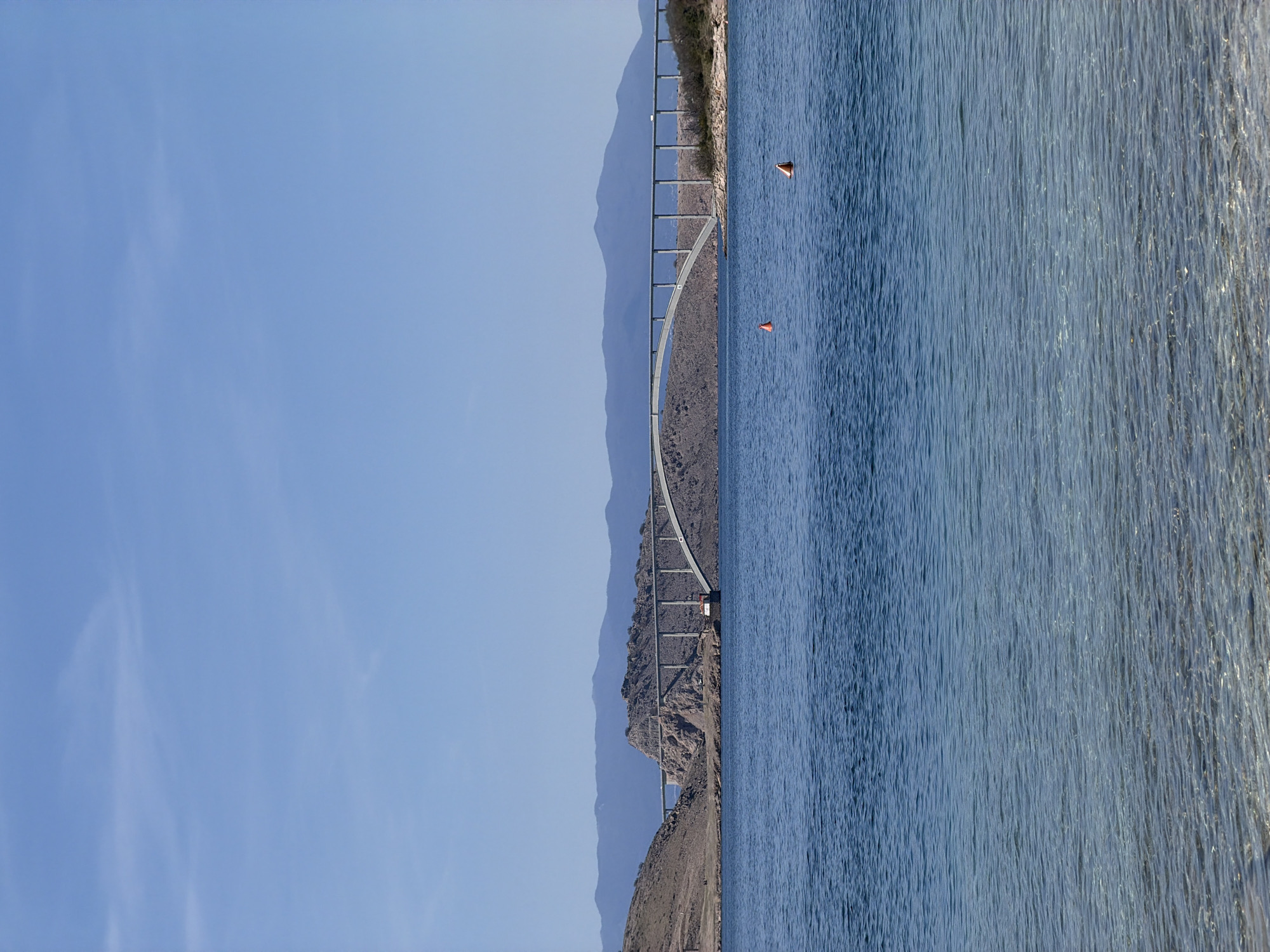 Clear day captures Krk Bridge and beachgoer in Jadranovo
