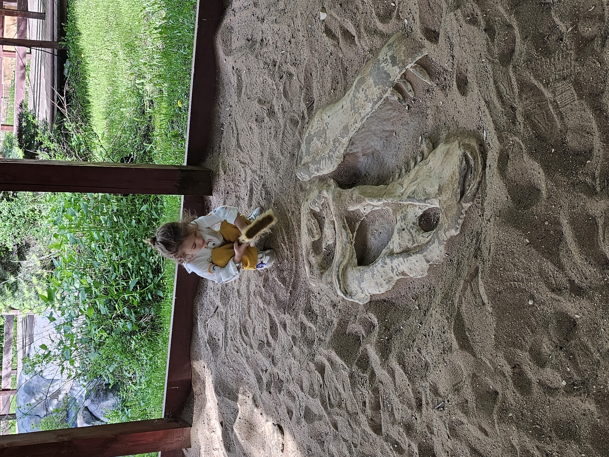 Child plays with dinosaur replicas in Khimki sandbox playground