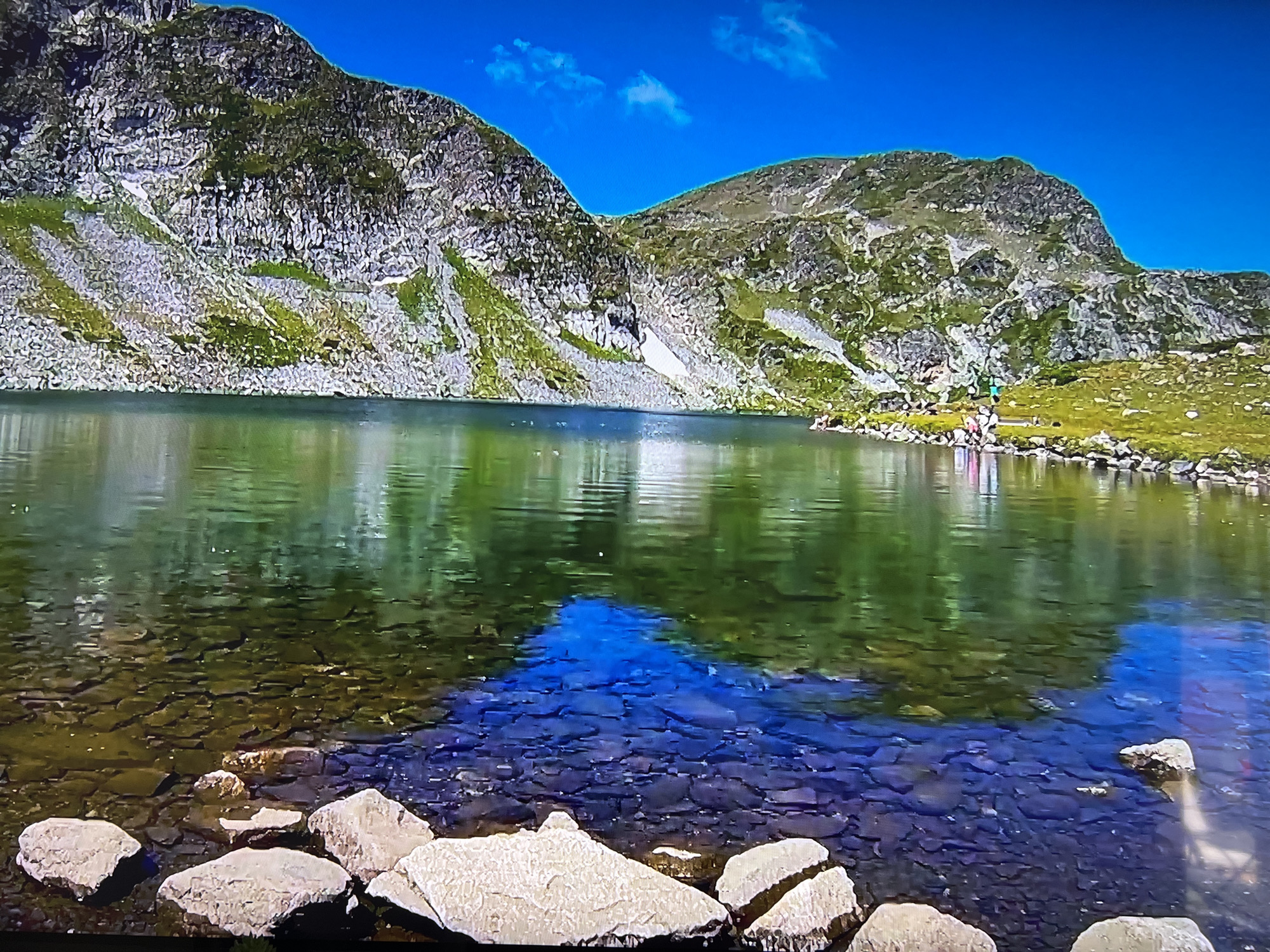 Mountain lake with clear water and rocks documented